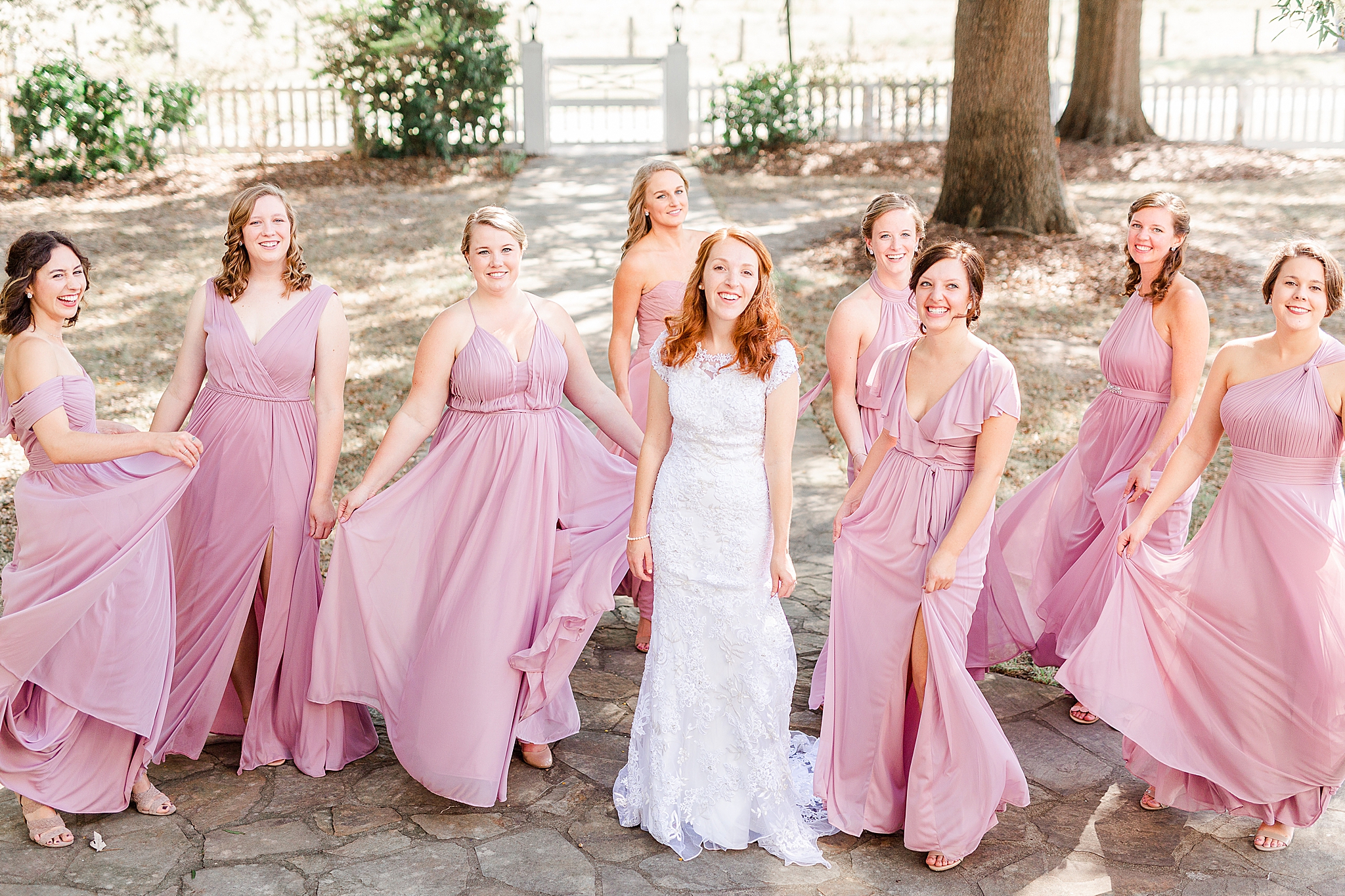 bridesmaids twirl in gowns with bride