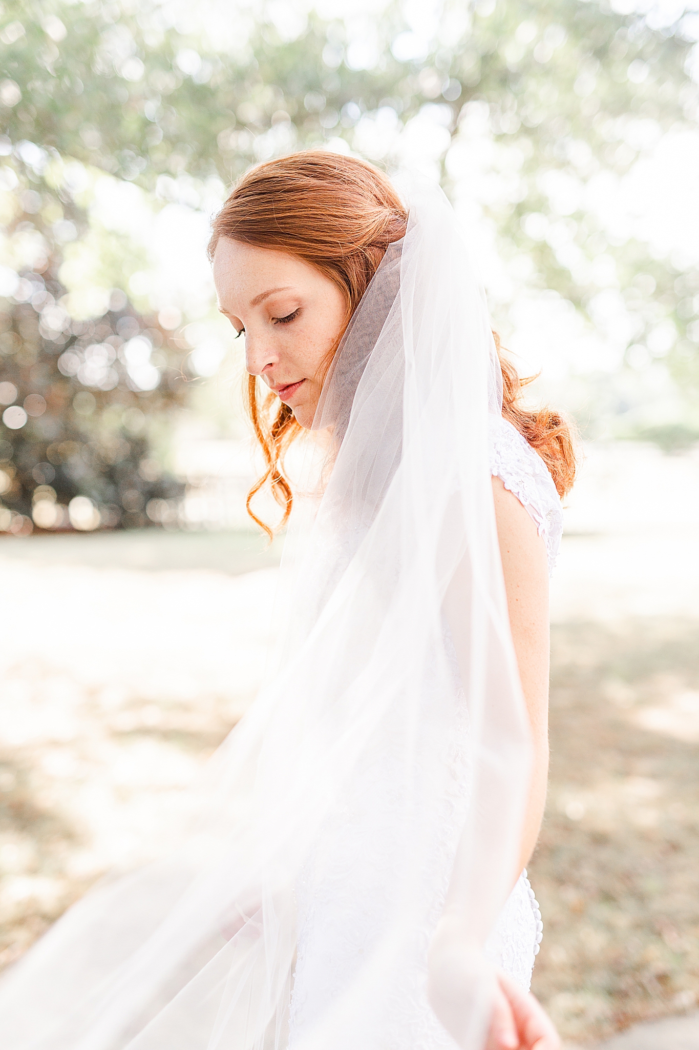 bride pulls veil around shoulders during southern bridal portraits