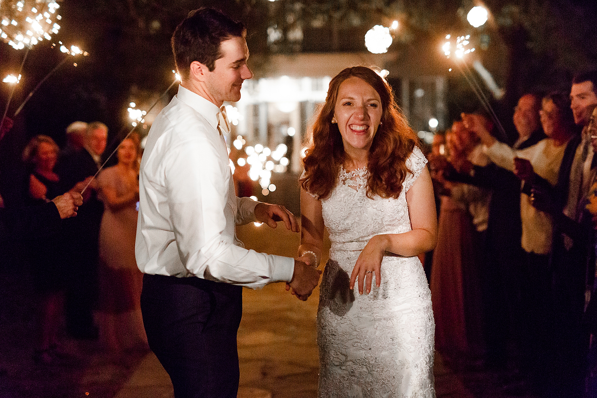 bride and groom laugh during sparkler exit