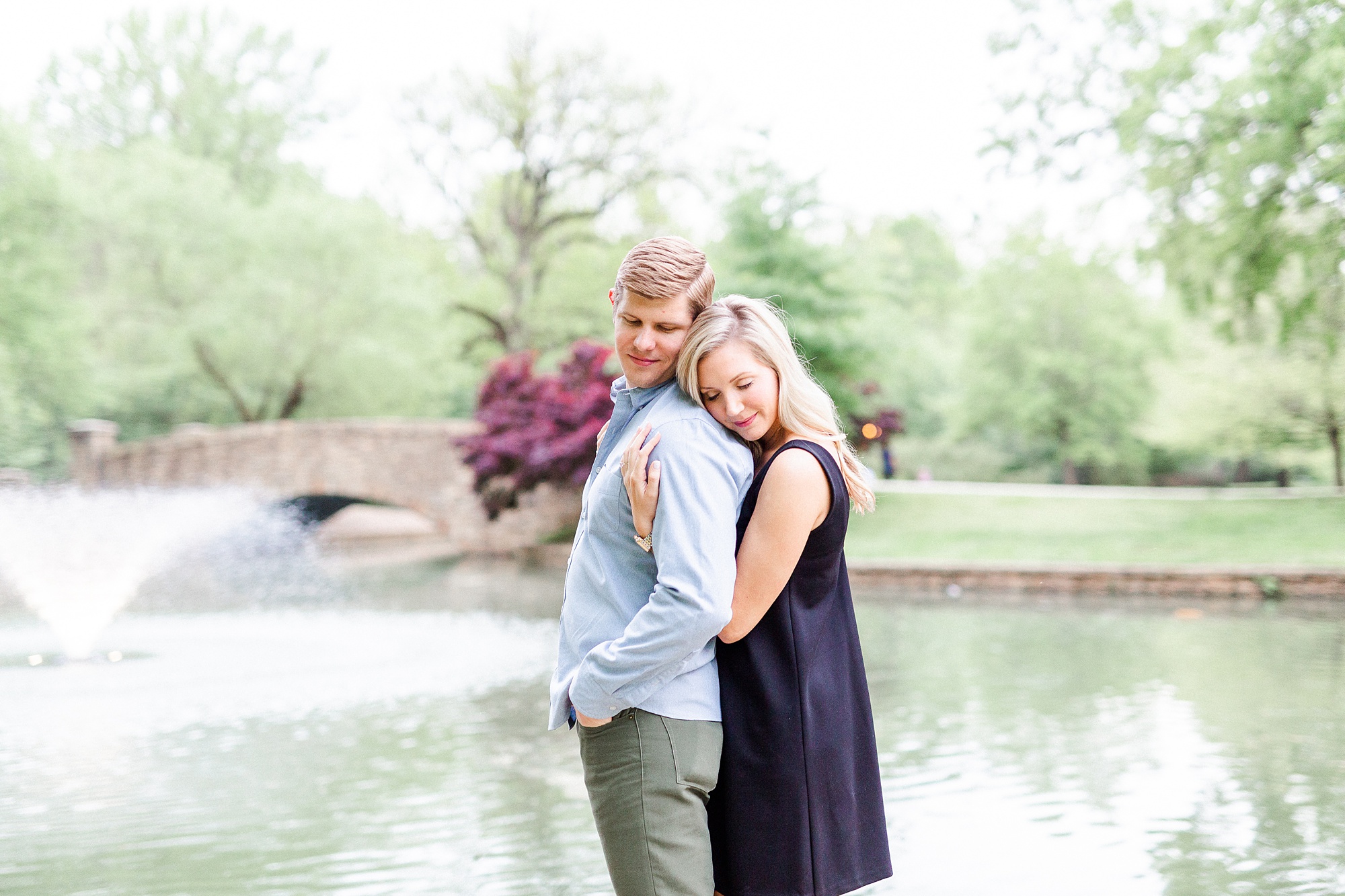 bride hugs groom from behind during stylish Charlotte engagement photos