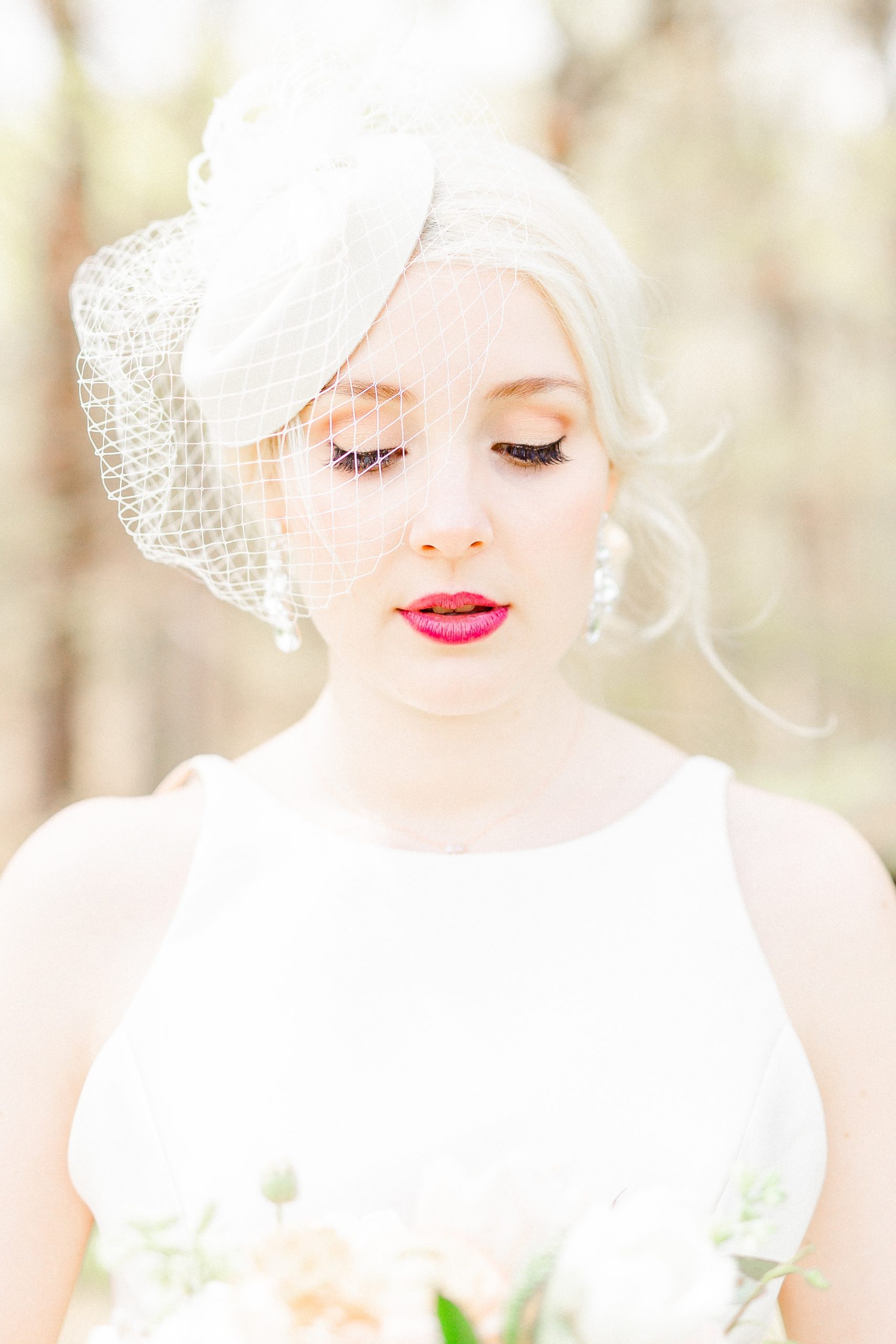 bridal portrait of bride with red lips and birdcage veil
