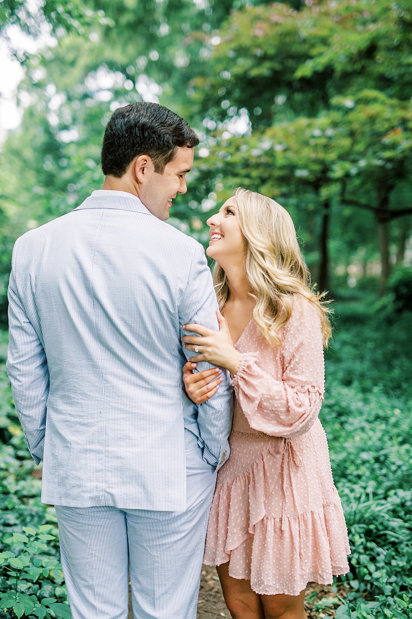 bride laughs up at groom during uptown Charlotte engagement photos