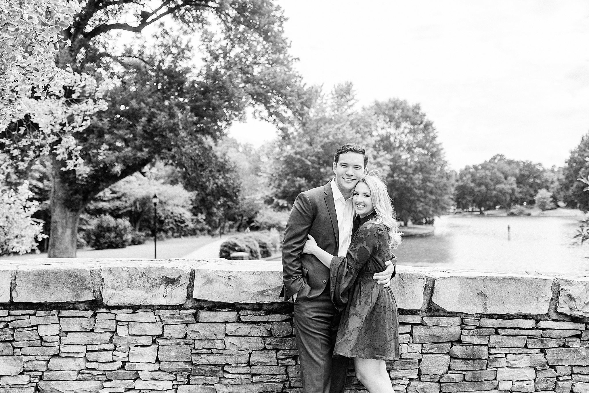 engaged couple leans against stone wall in Freedom Park