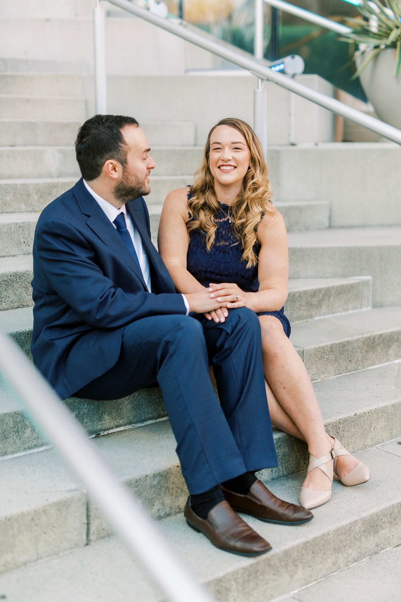 engaged couple laughs on steps of Mint Museum