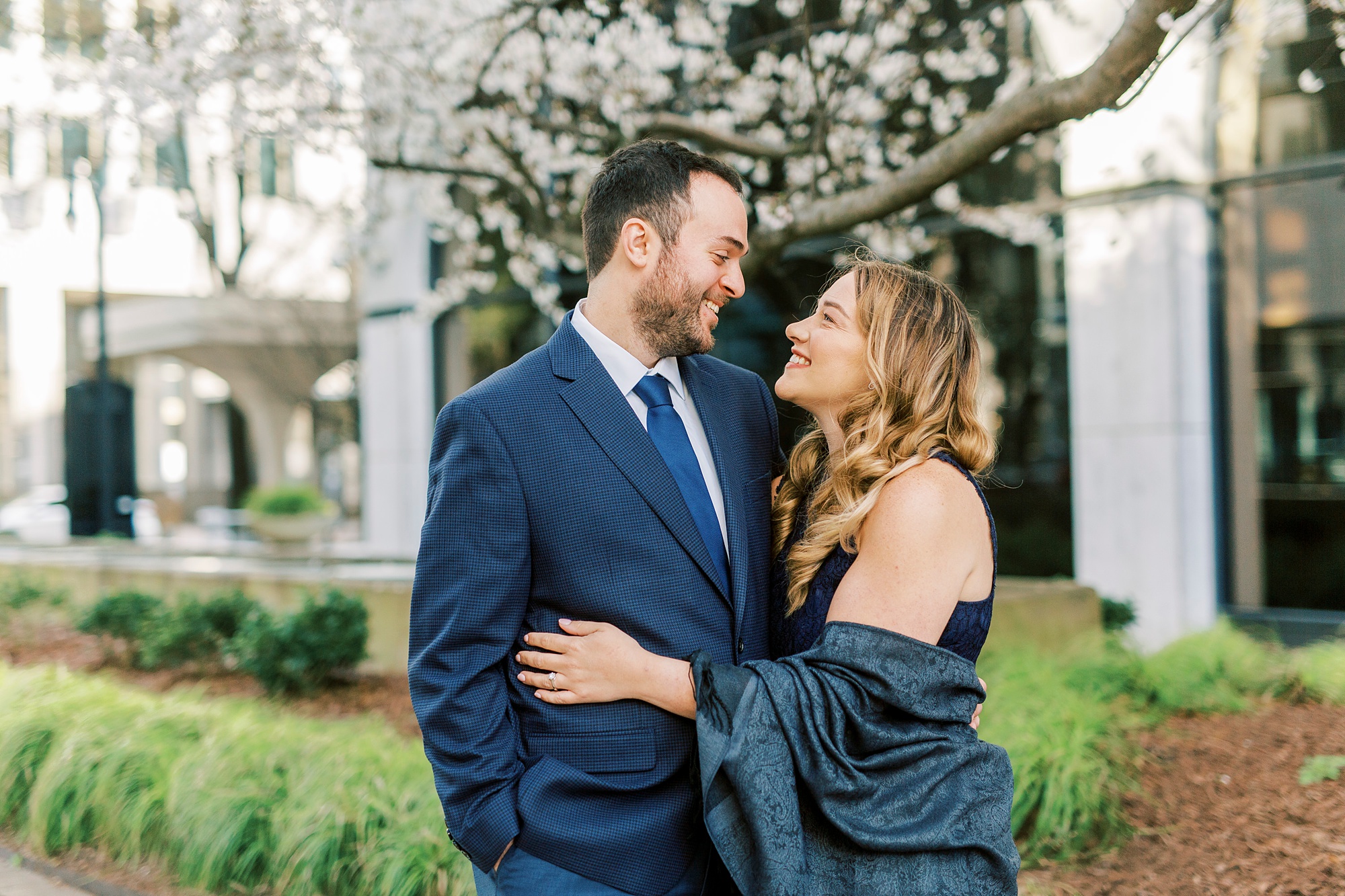 bride and groom pose under tree in Uptown Charlotte