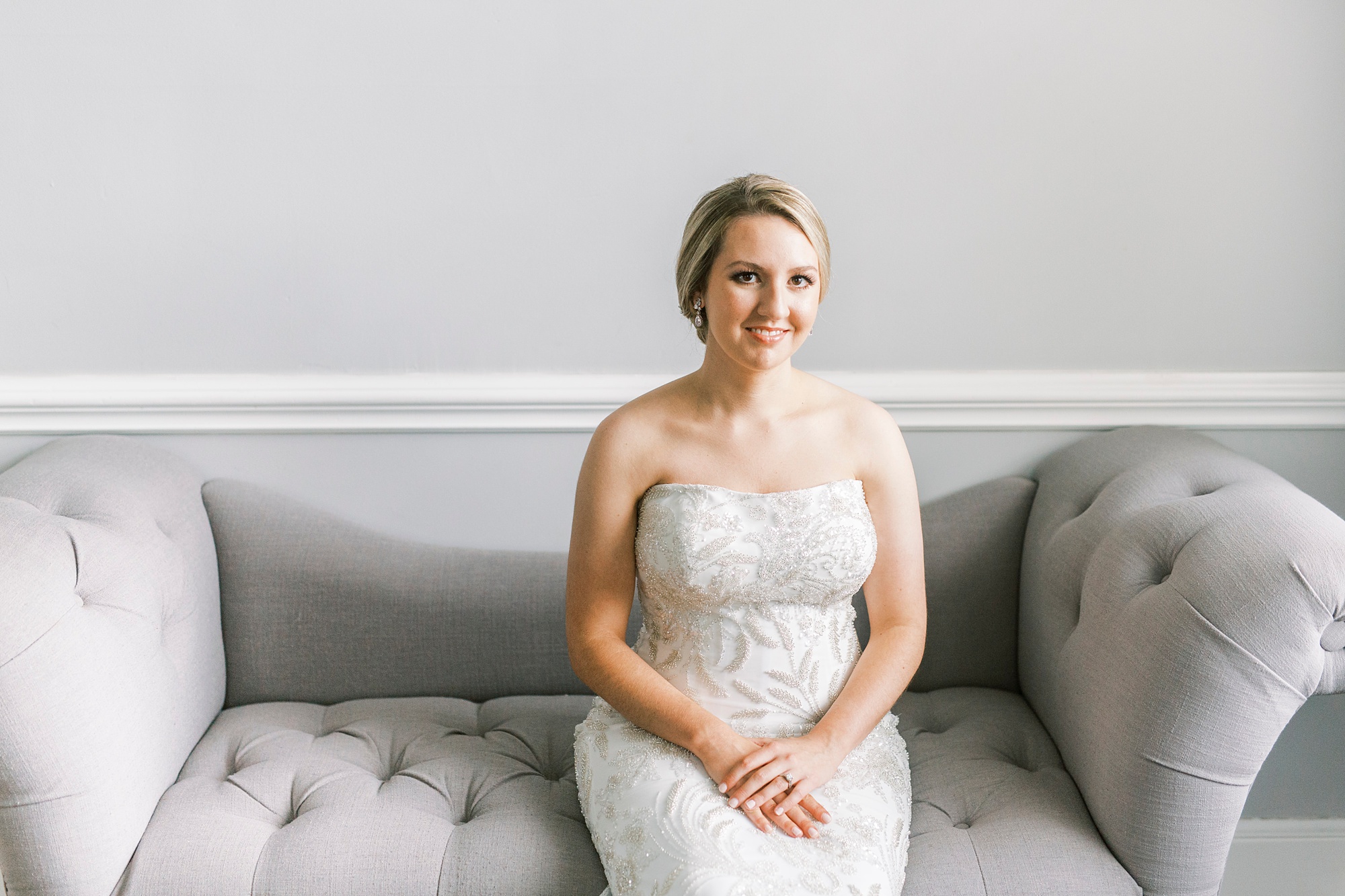 bride sits on grey couch in Separk Mansion