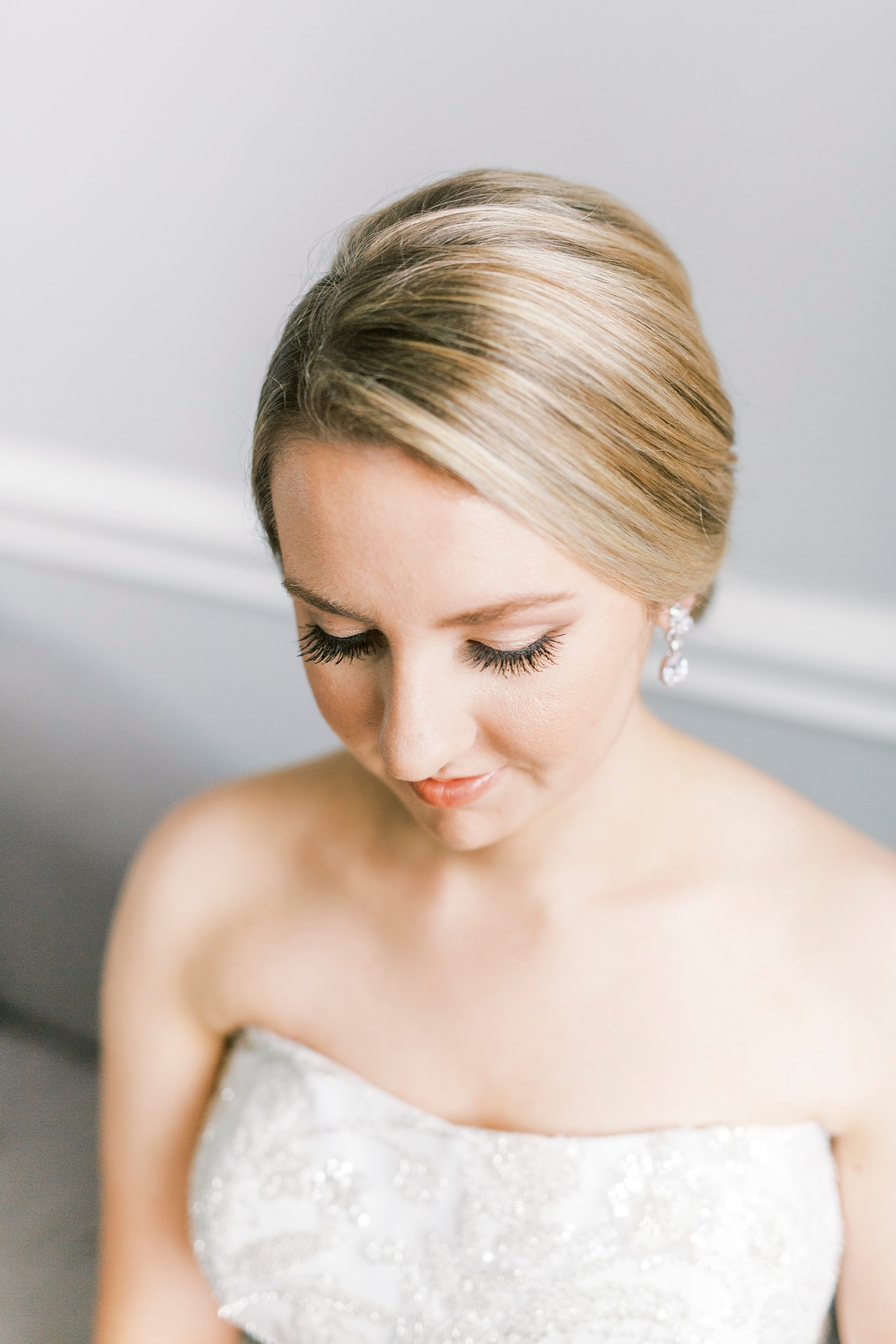 bride with classic updo looks at lap during NC bridal portraits