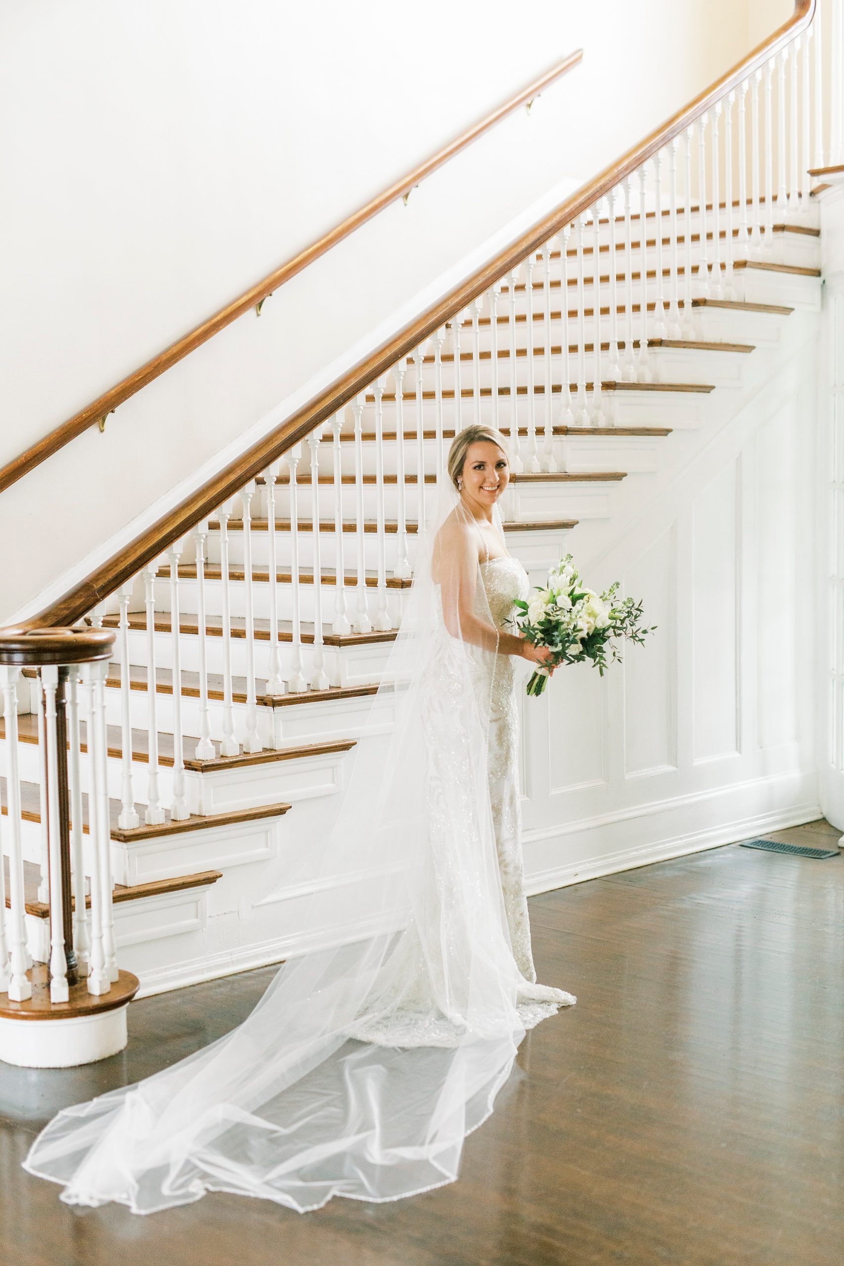 bride poses by staircase in Charlotte NC