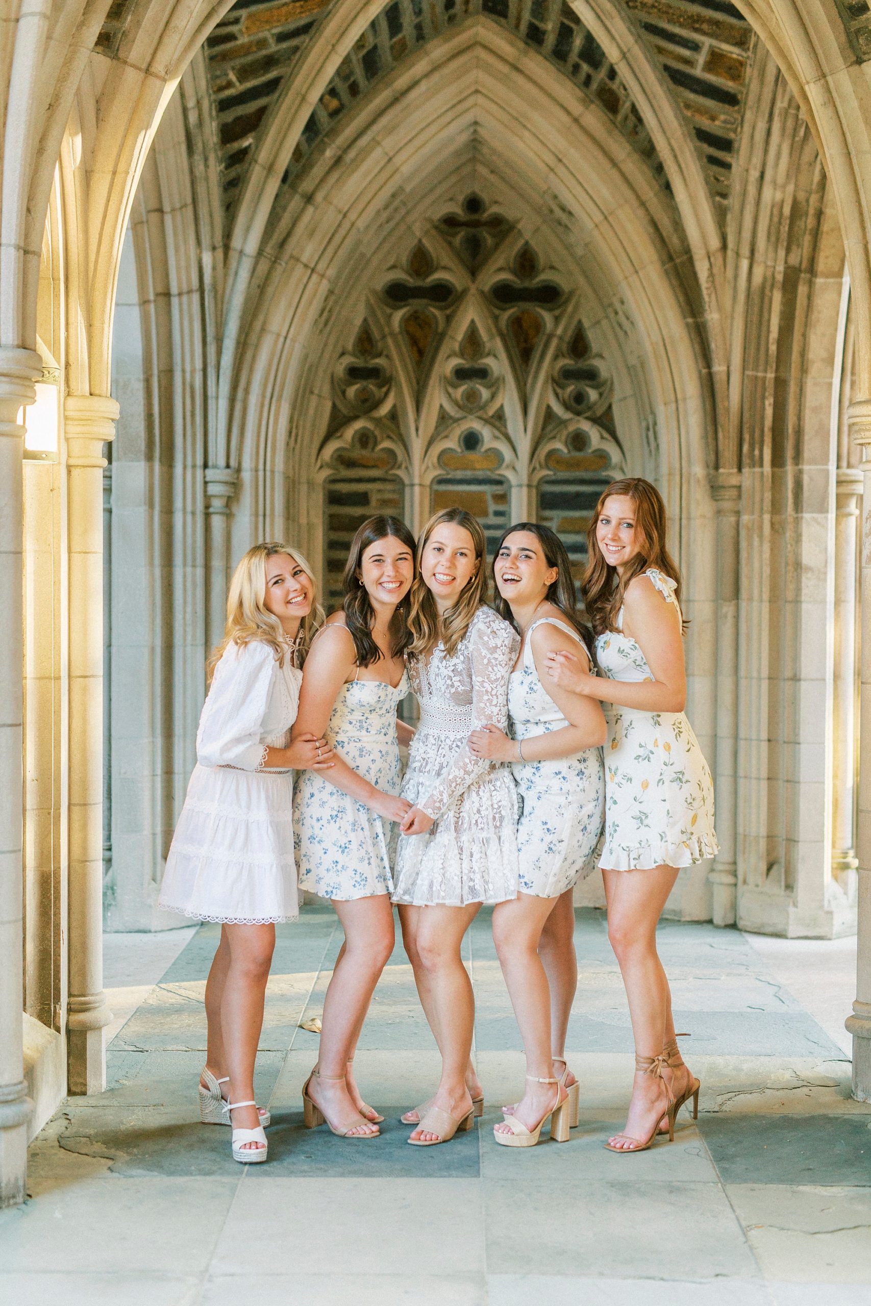 girls pose by archway at Duke Chapel