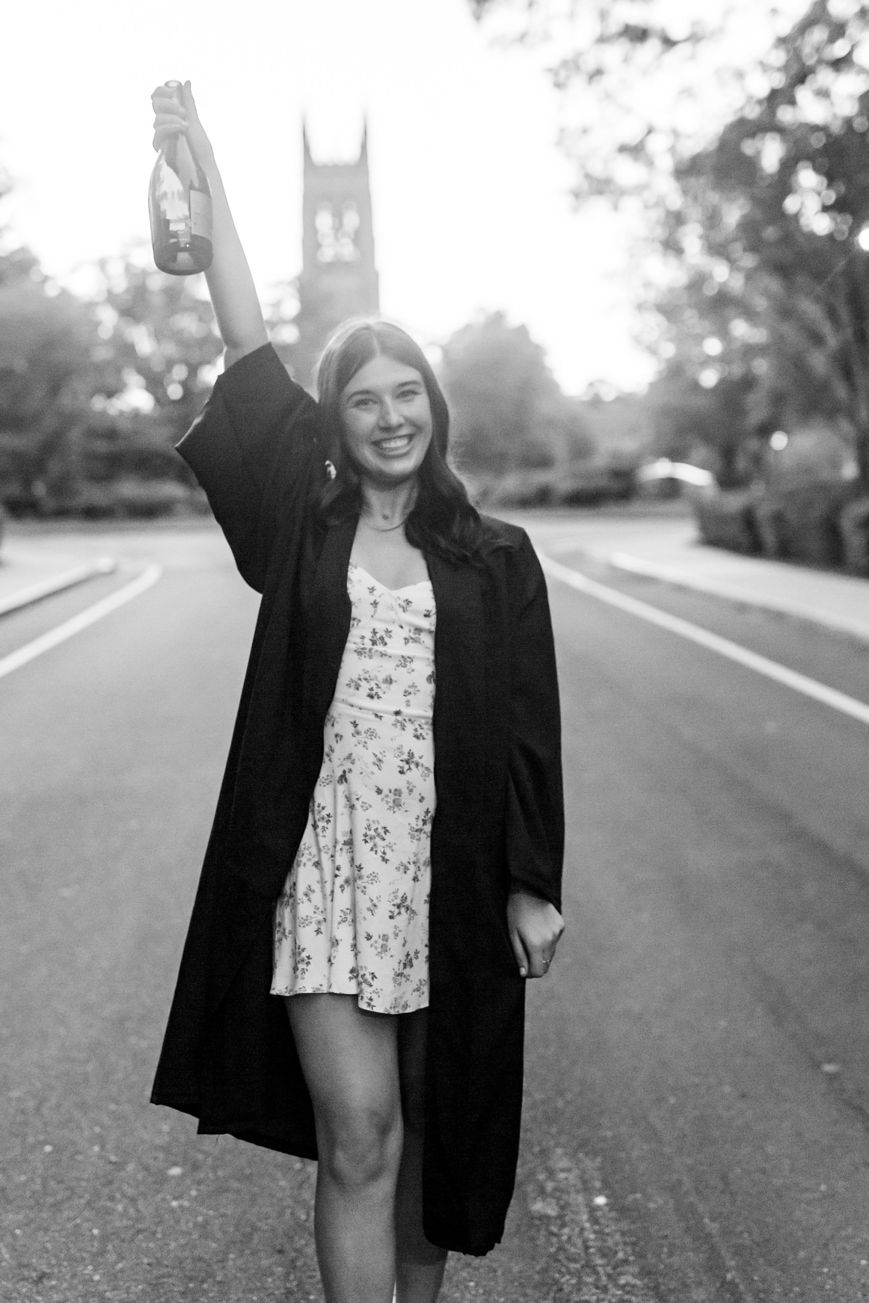 senior holds bottle of champagne during Duke University graduation portraits