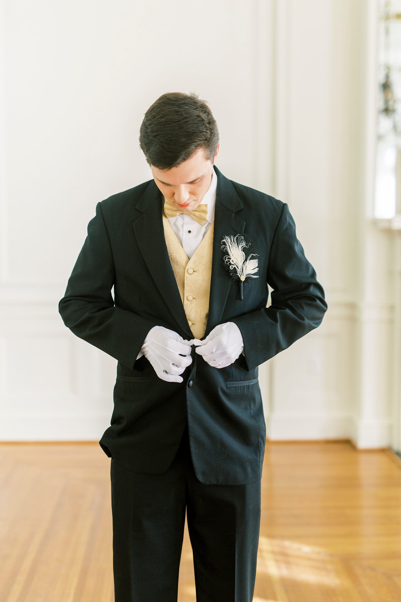 young man adjusts suit before Great Gatsby birthday party
