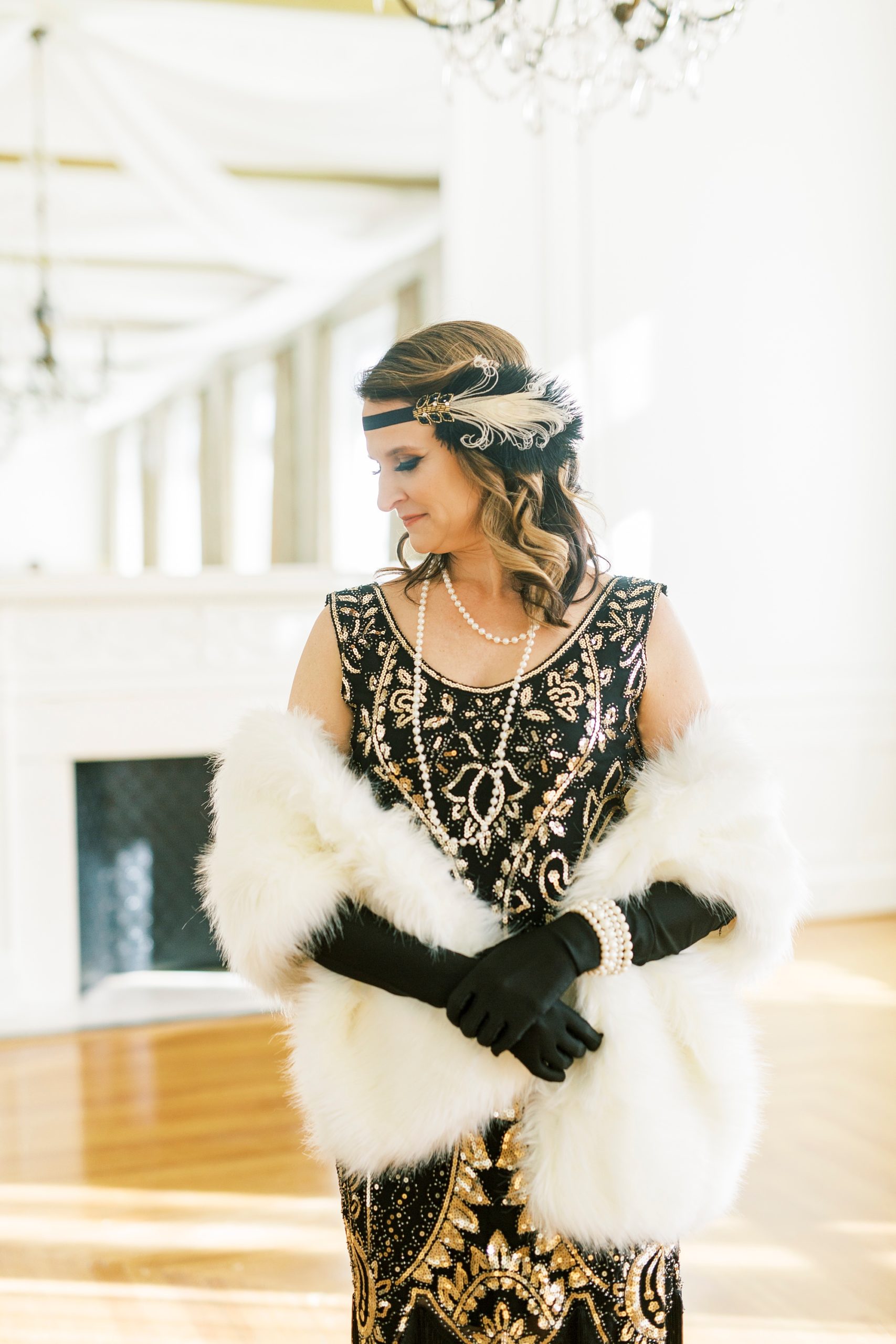 woman in gold and black flapper dress poses during Great Gatsby birthday party