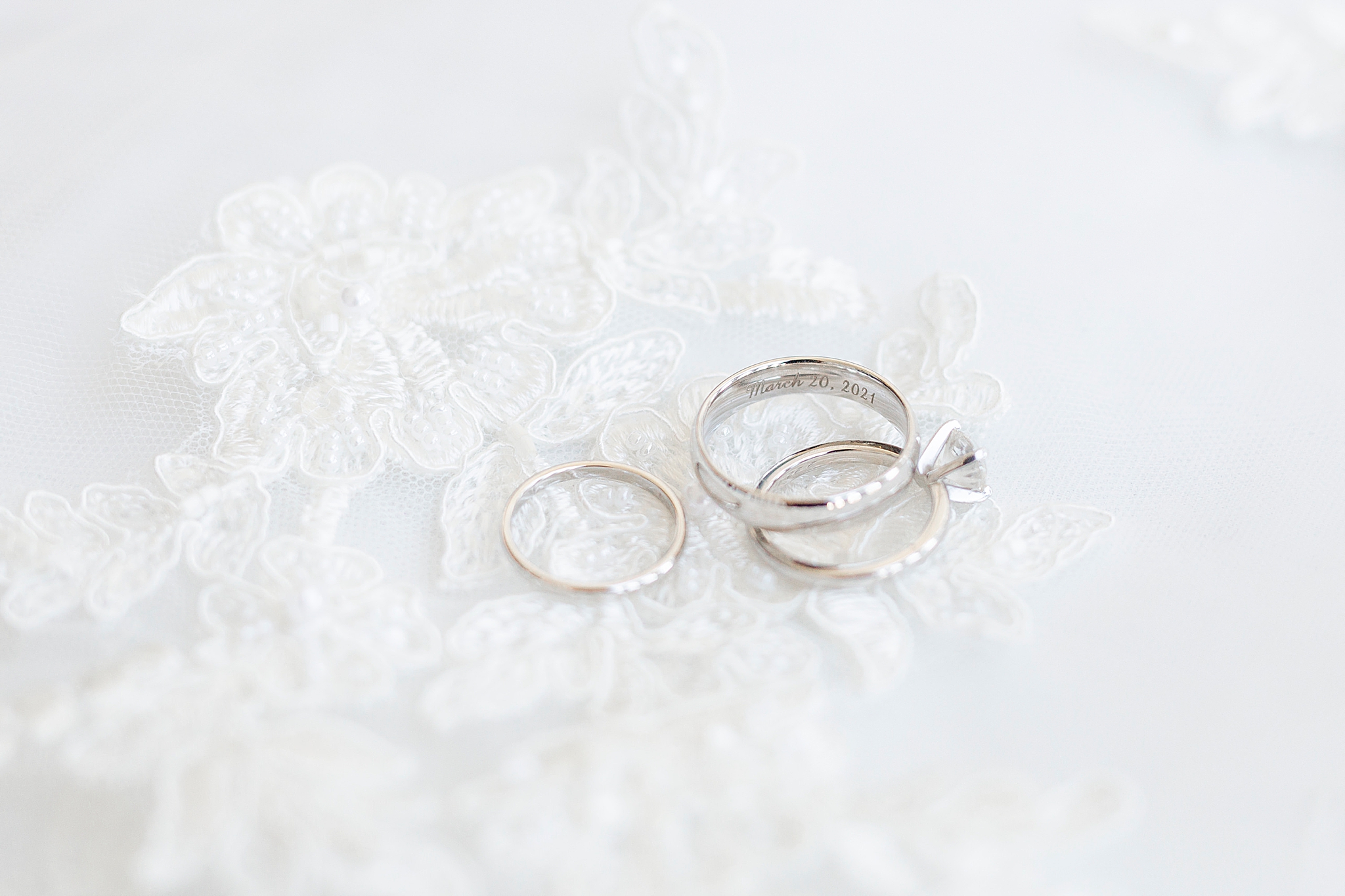 wedding rings lay on bride's wedding dress
