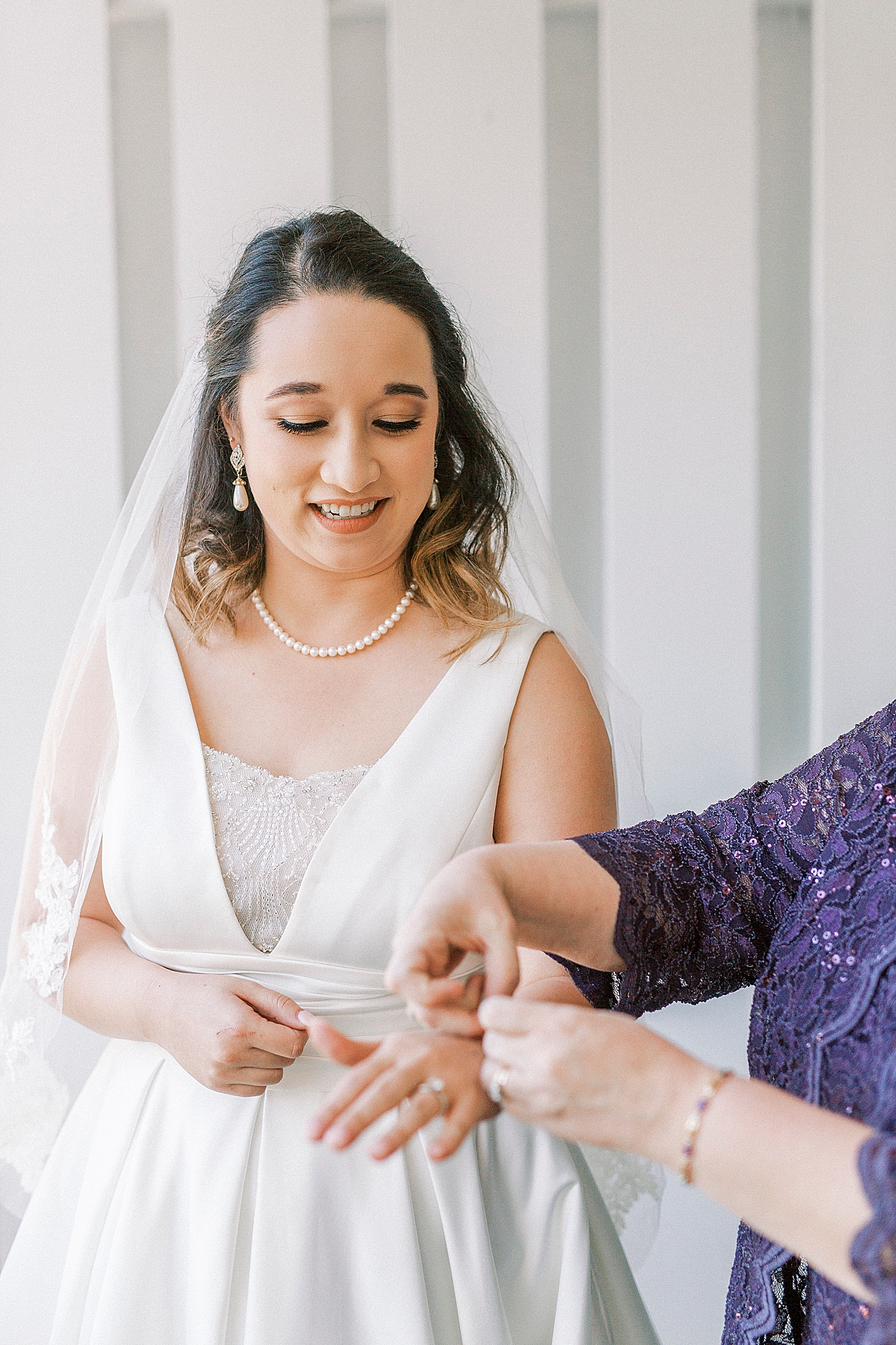 mother helps bride with bracelet on wedding morning