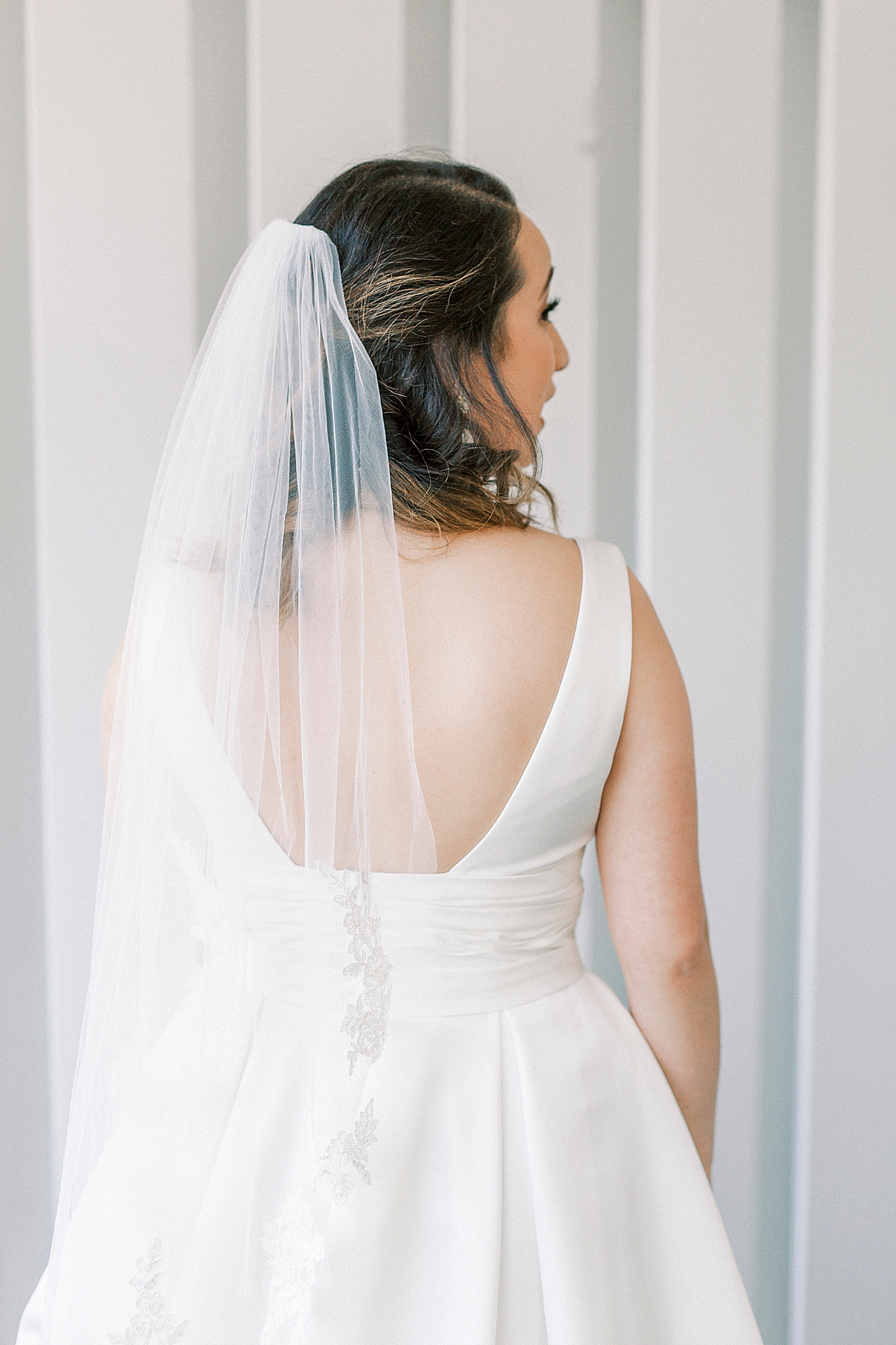 bride looks over shoulder of classic gown
