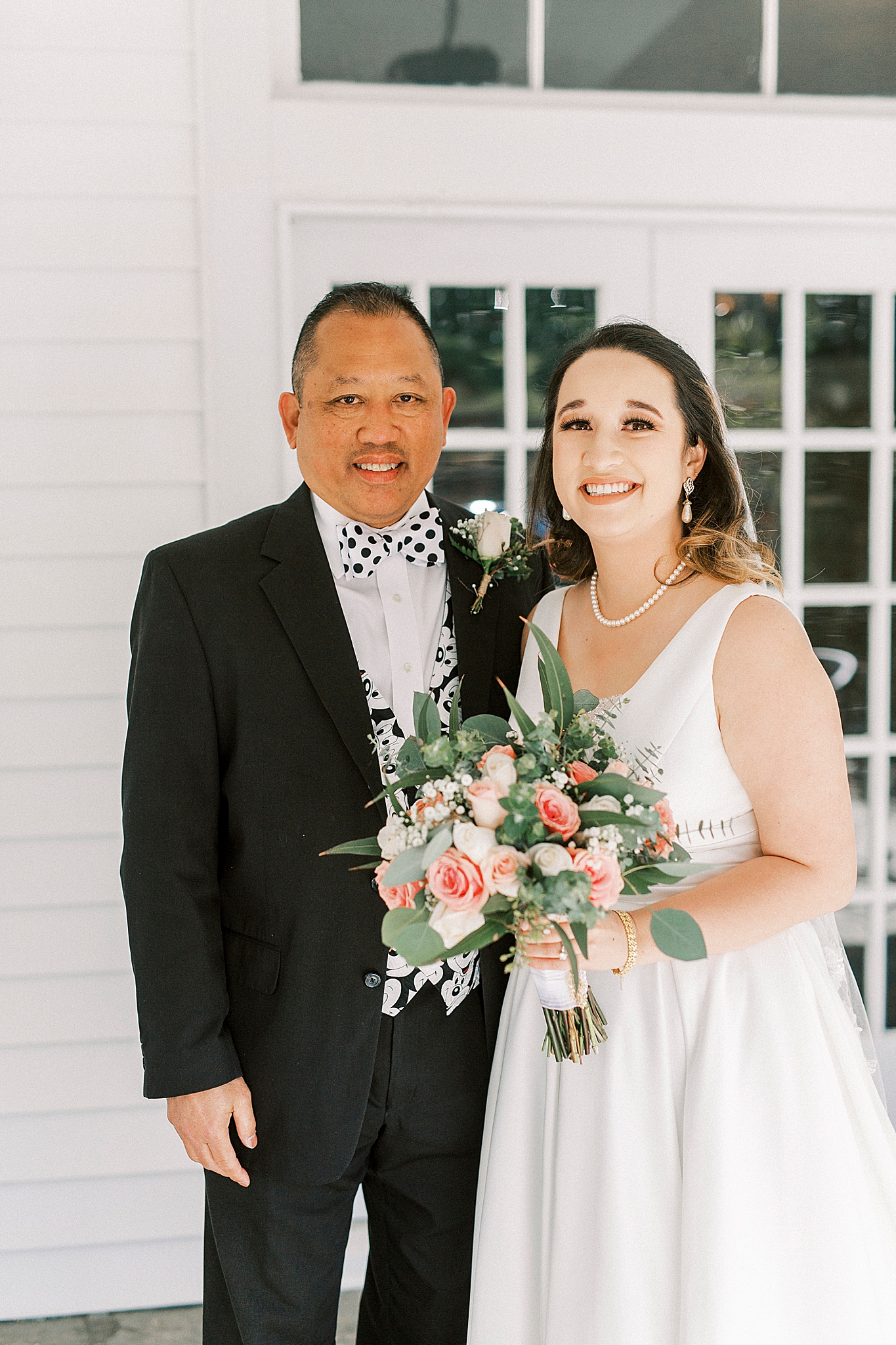 bride poses with dad with Mickey Mouse tie and cumber band