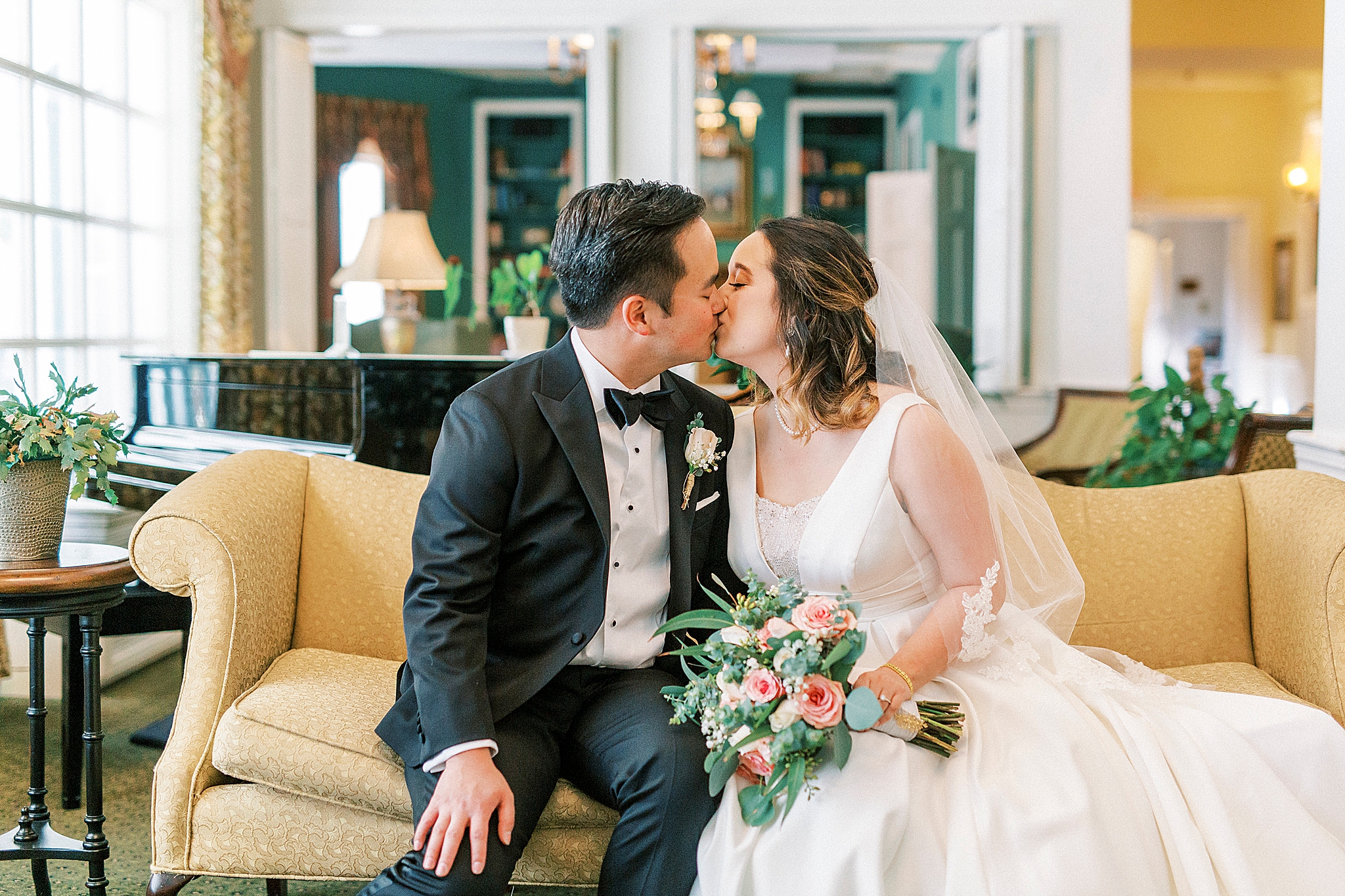 newlyweds kiss on couch during Green Park Inn wedding photos