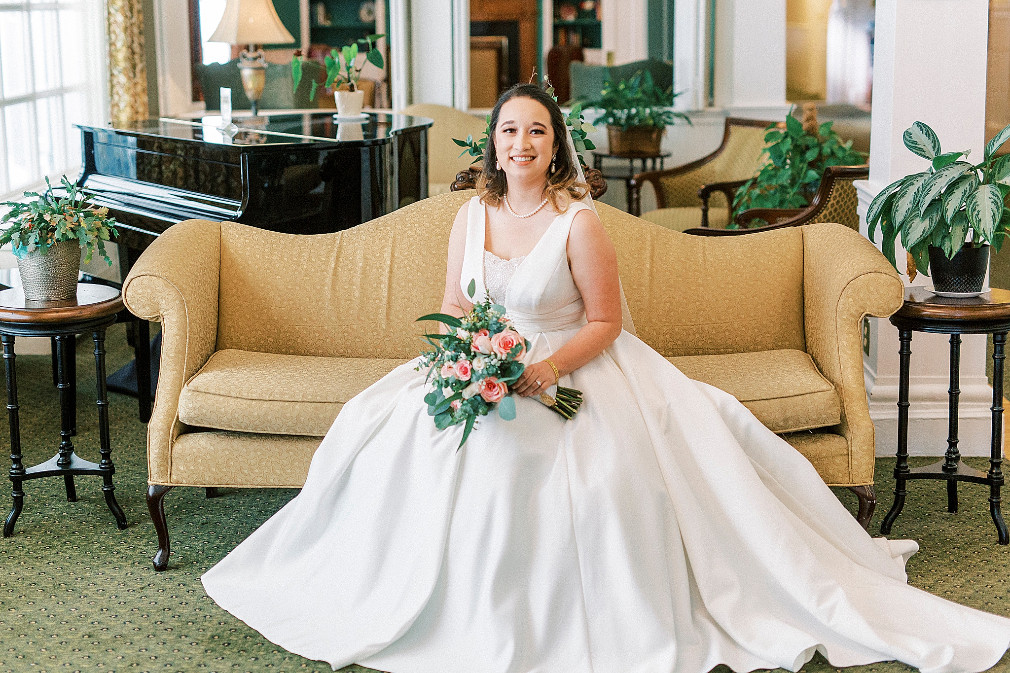 bridal portrait with bride's gown spread around couch