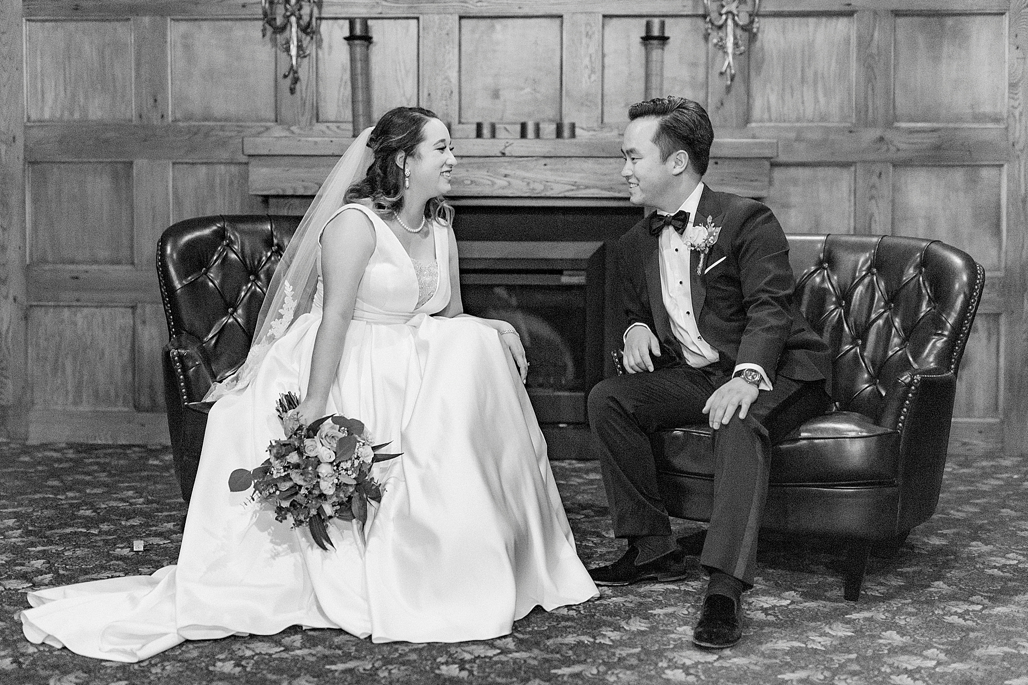 bride and groom sit on leather couch during Green Park Inn wedding photos