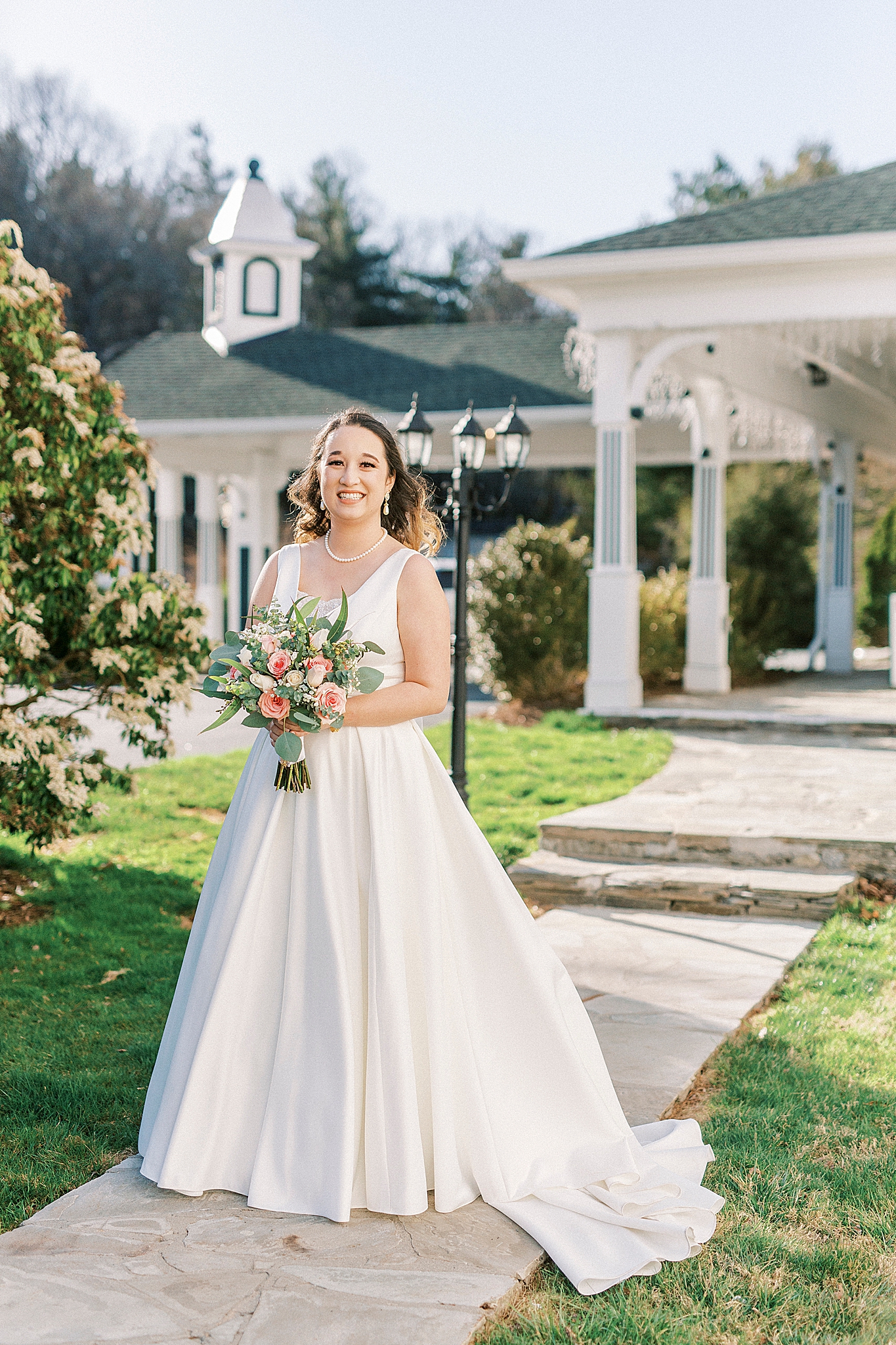 bride walks holding bouquet of roses