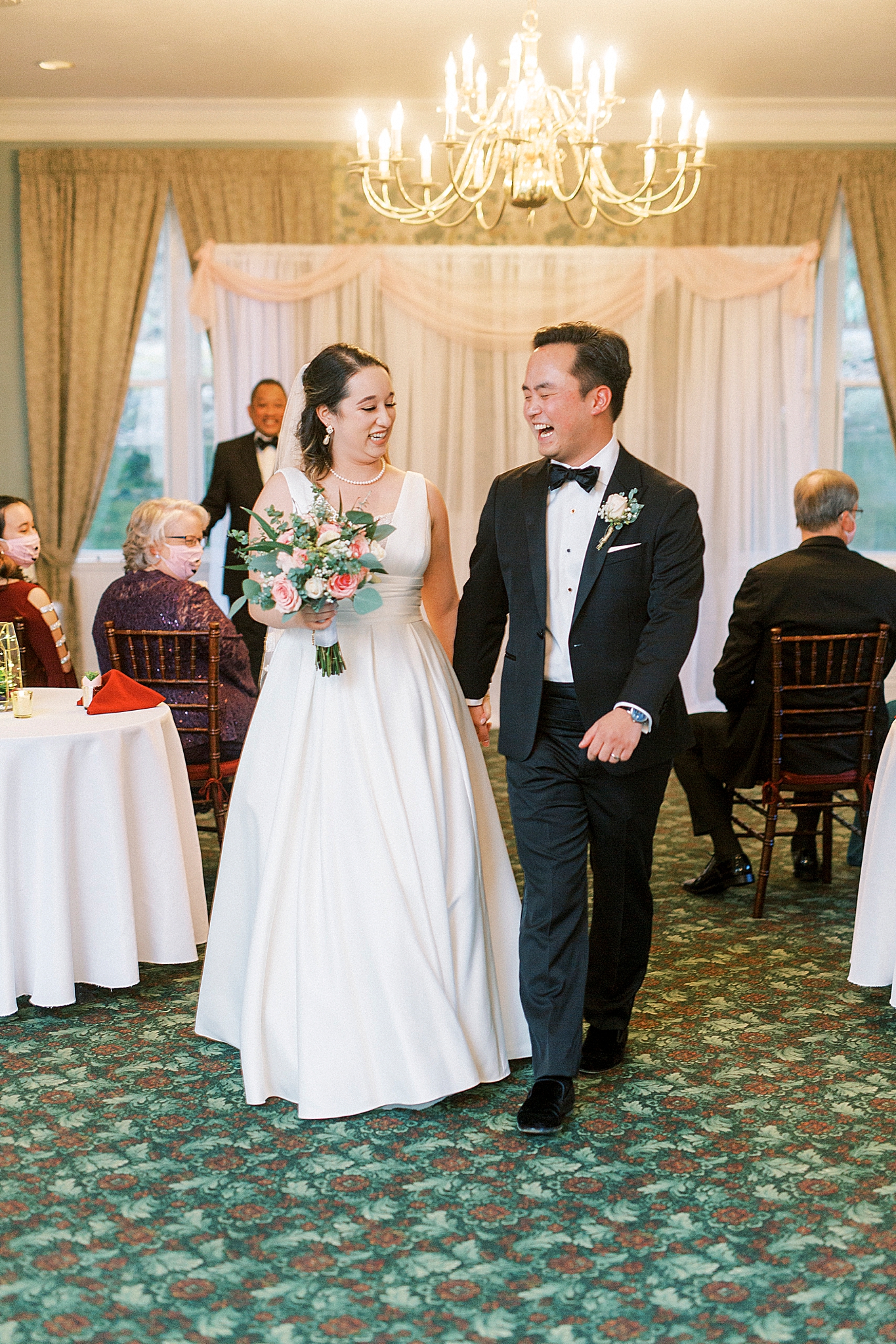 newlyweds laugh together walking up aisle at Green Park Inn
