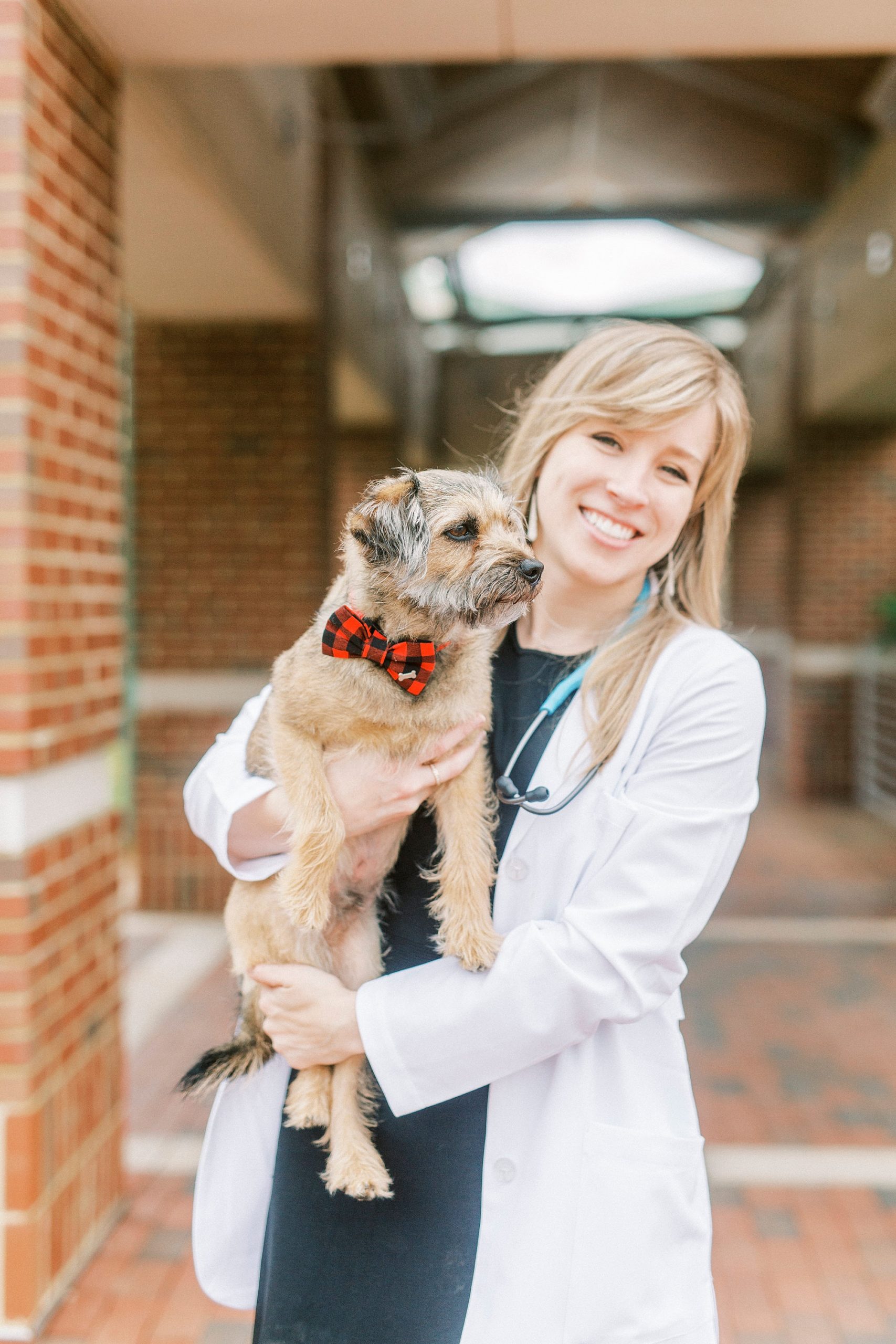 veterinary school graduate poses with dog in bowtie