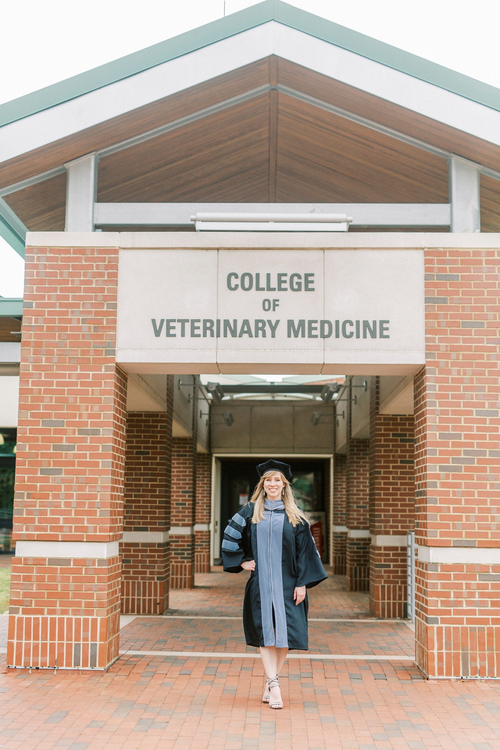 College of Veterinary medicine graduate poses outside sign