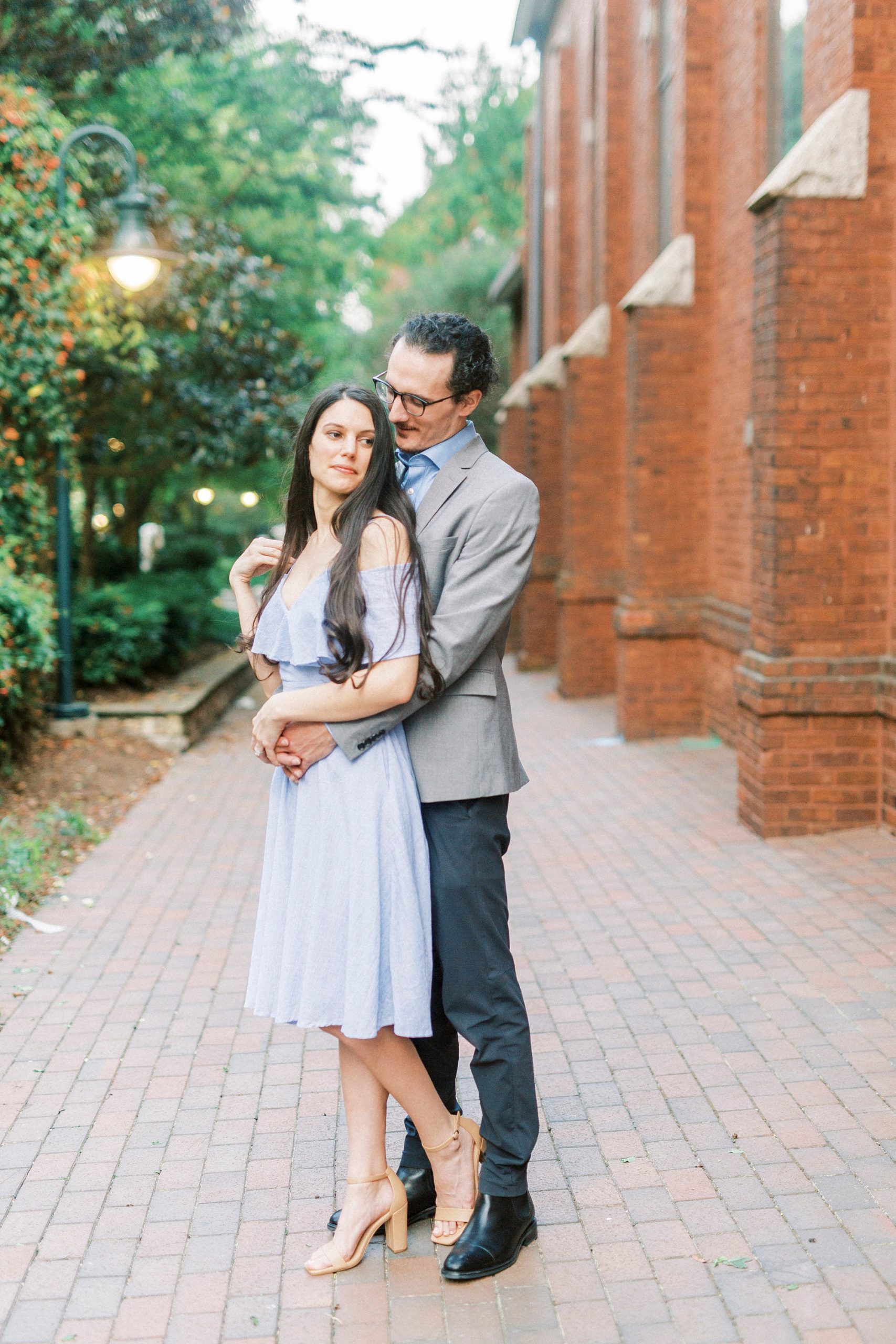 groom hugs bride from behind during engagement portraits in Charlotte NC