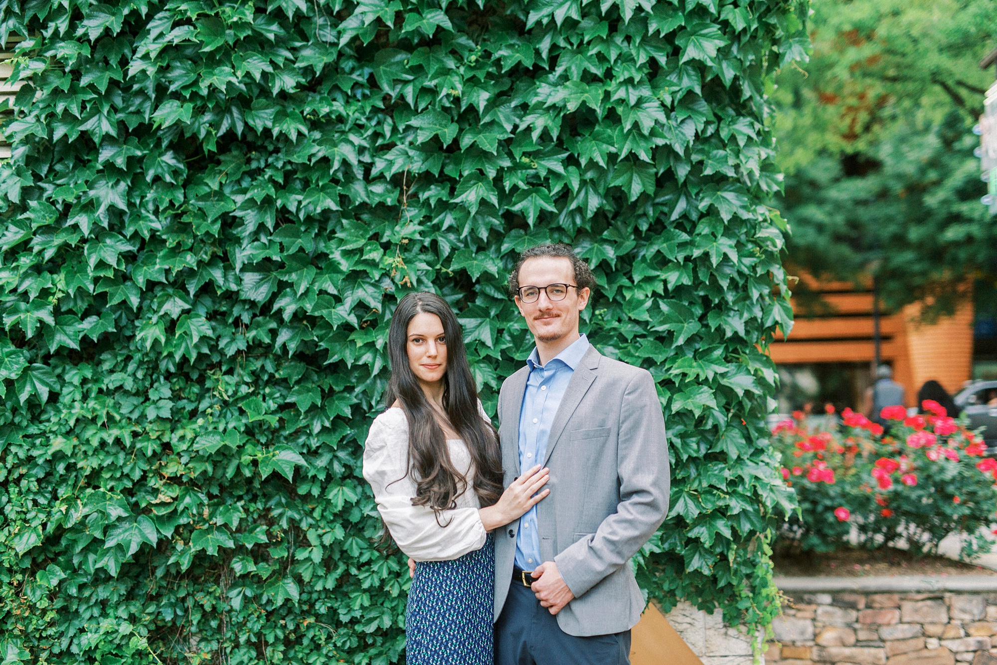 couple poses by ivy covered wall in Charlotte NC