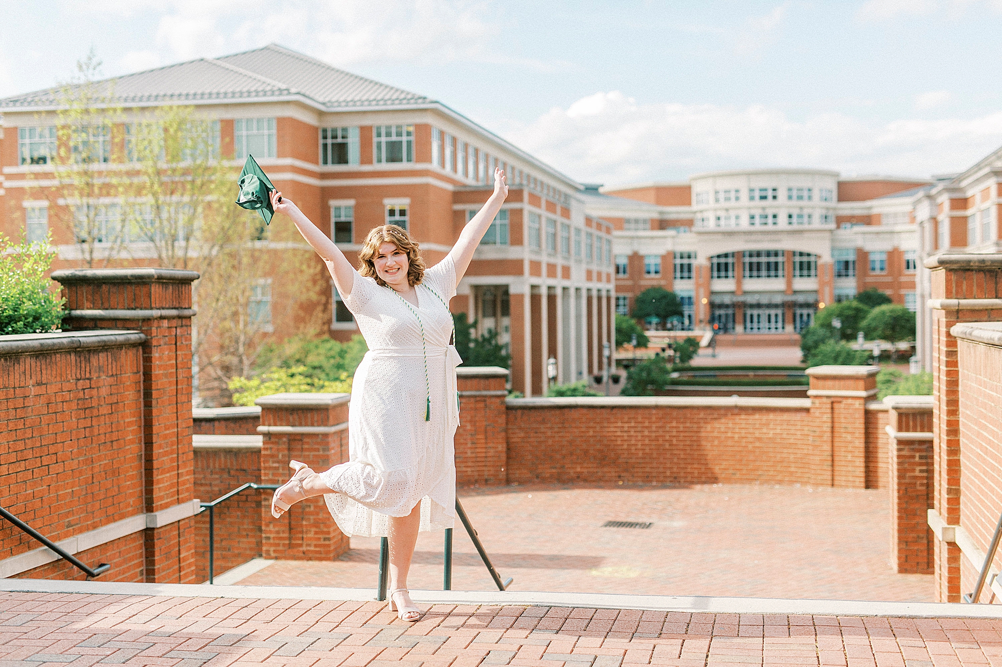 college graduate throws hands in the air celebrating
