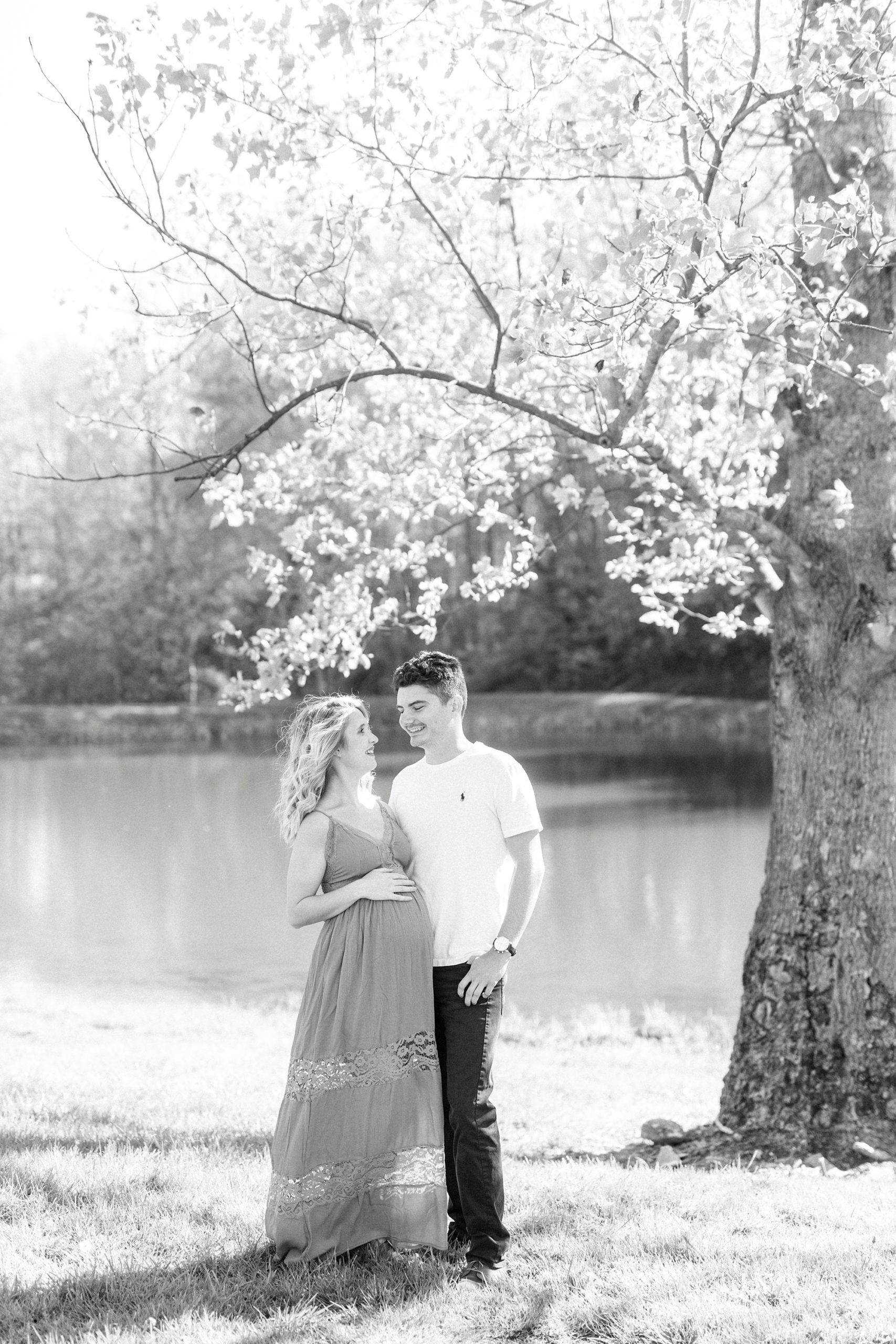 couple poses by tree during Winston-Salem maternity photos