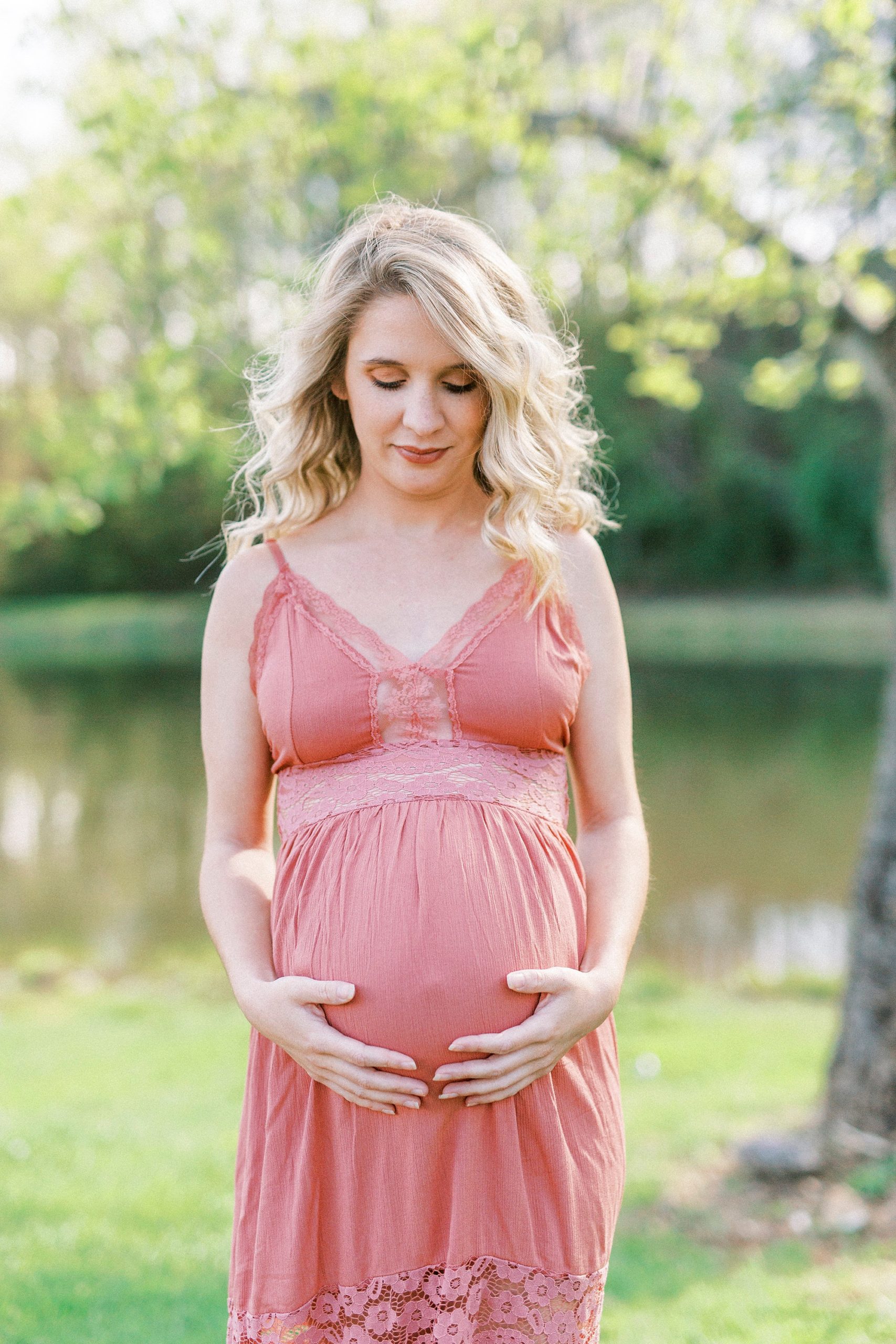 expecting mom holds baby belly during Winston-Salem maternity photos