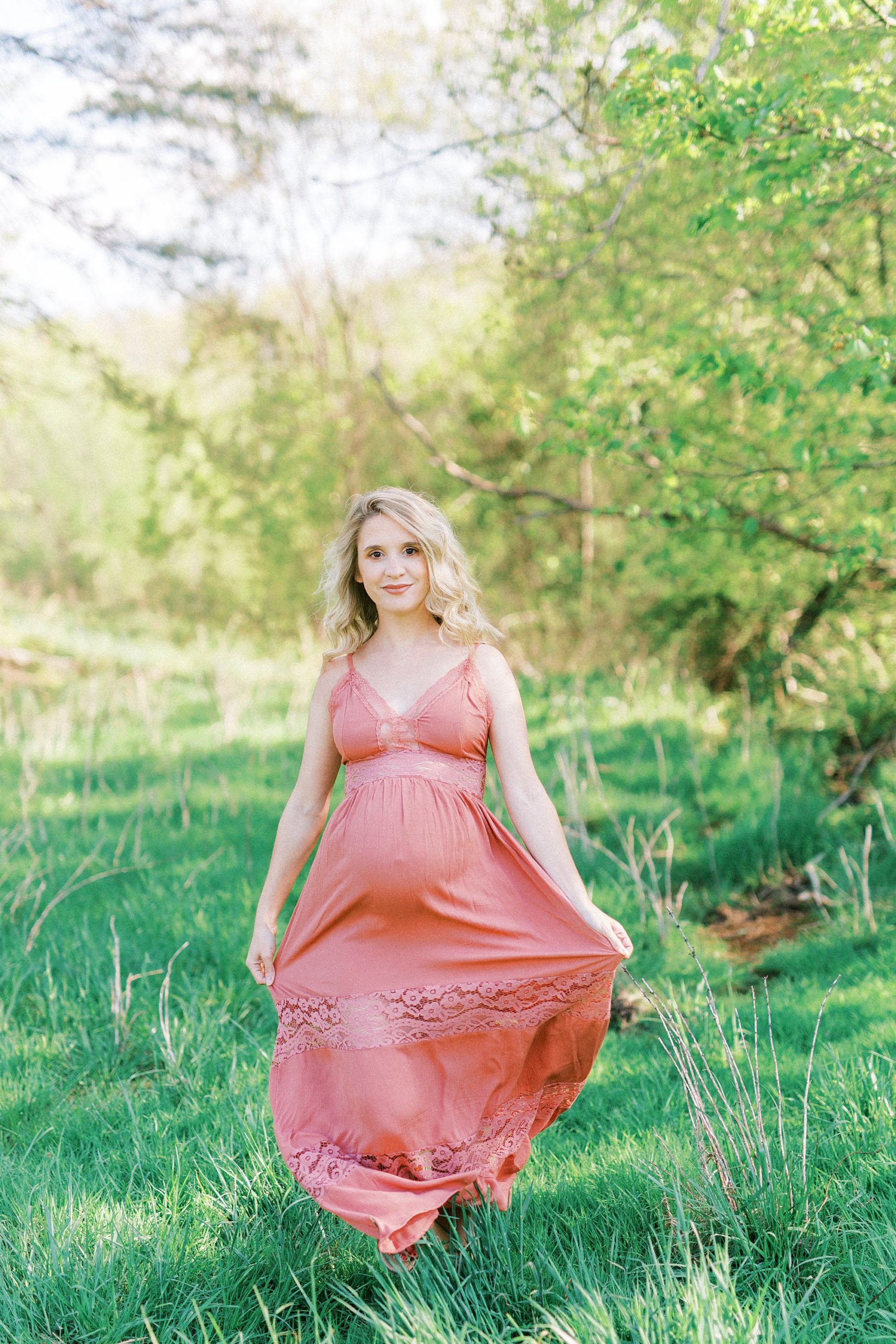 woman in pink sundress holds dress and walks forward