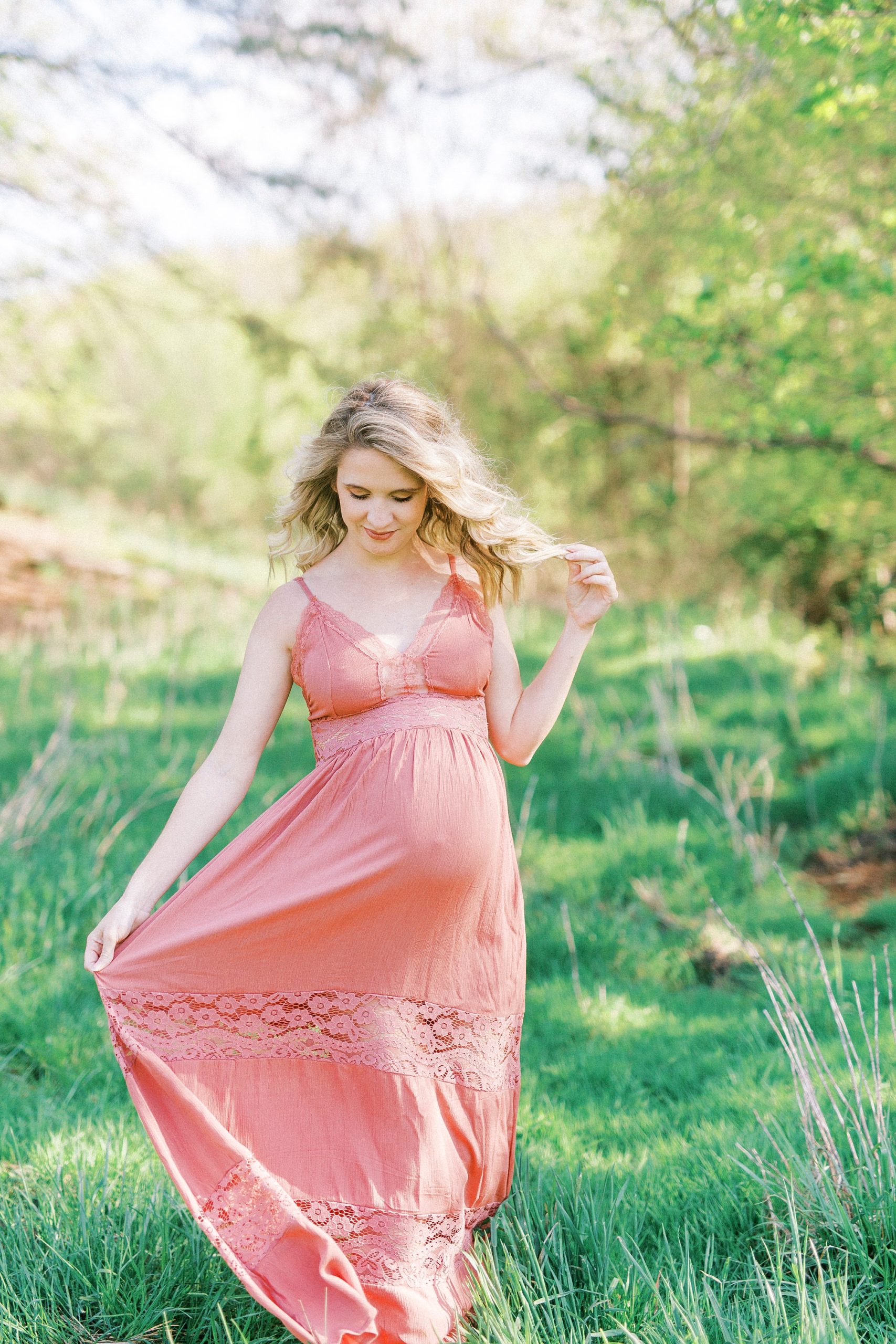 expecting mother twirls gown in field