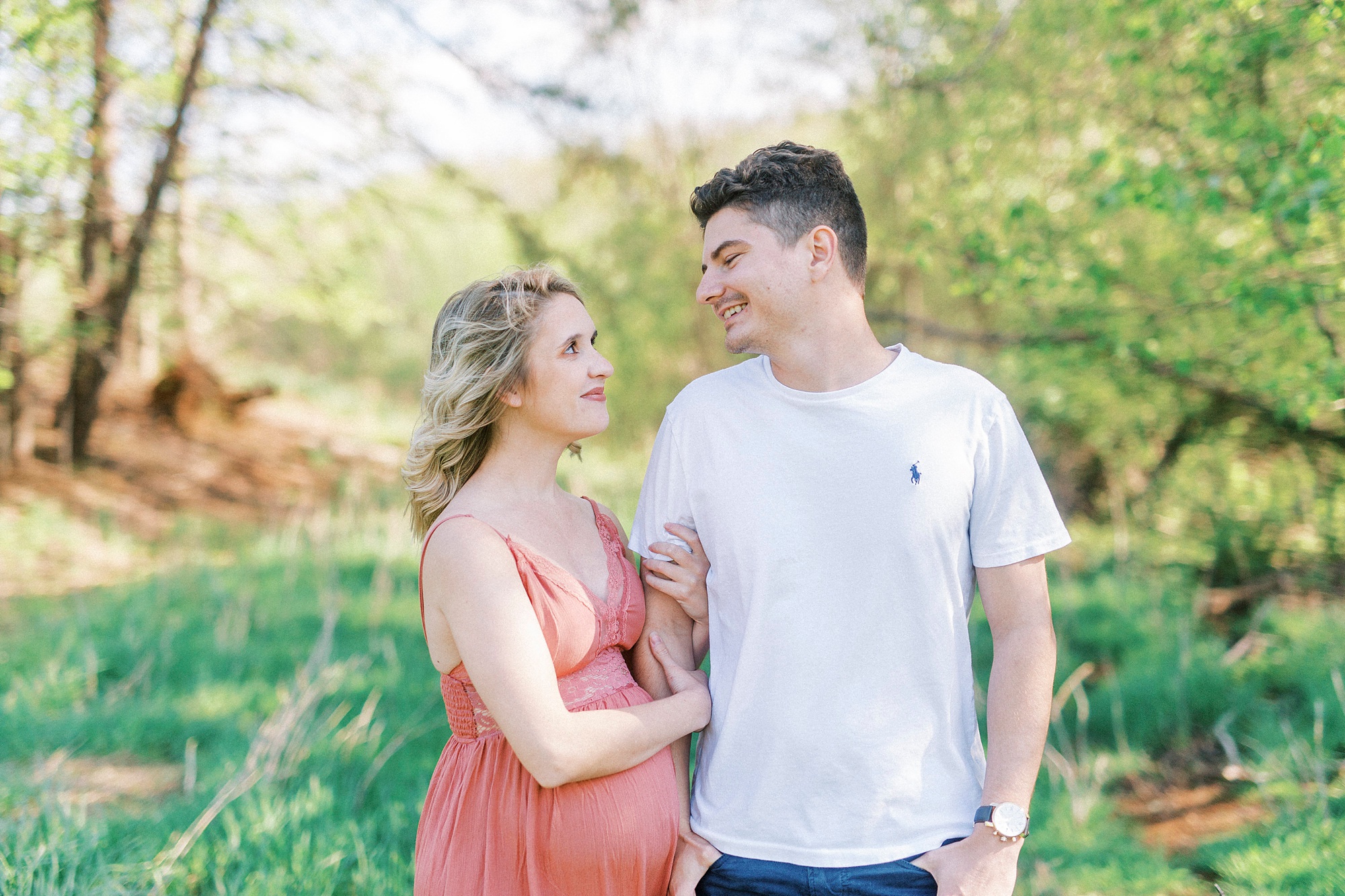 man and woman smile at each other during Winston-Salem maternity photos