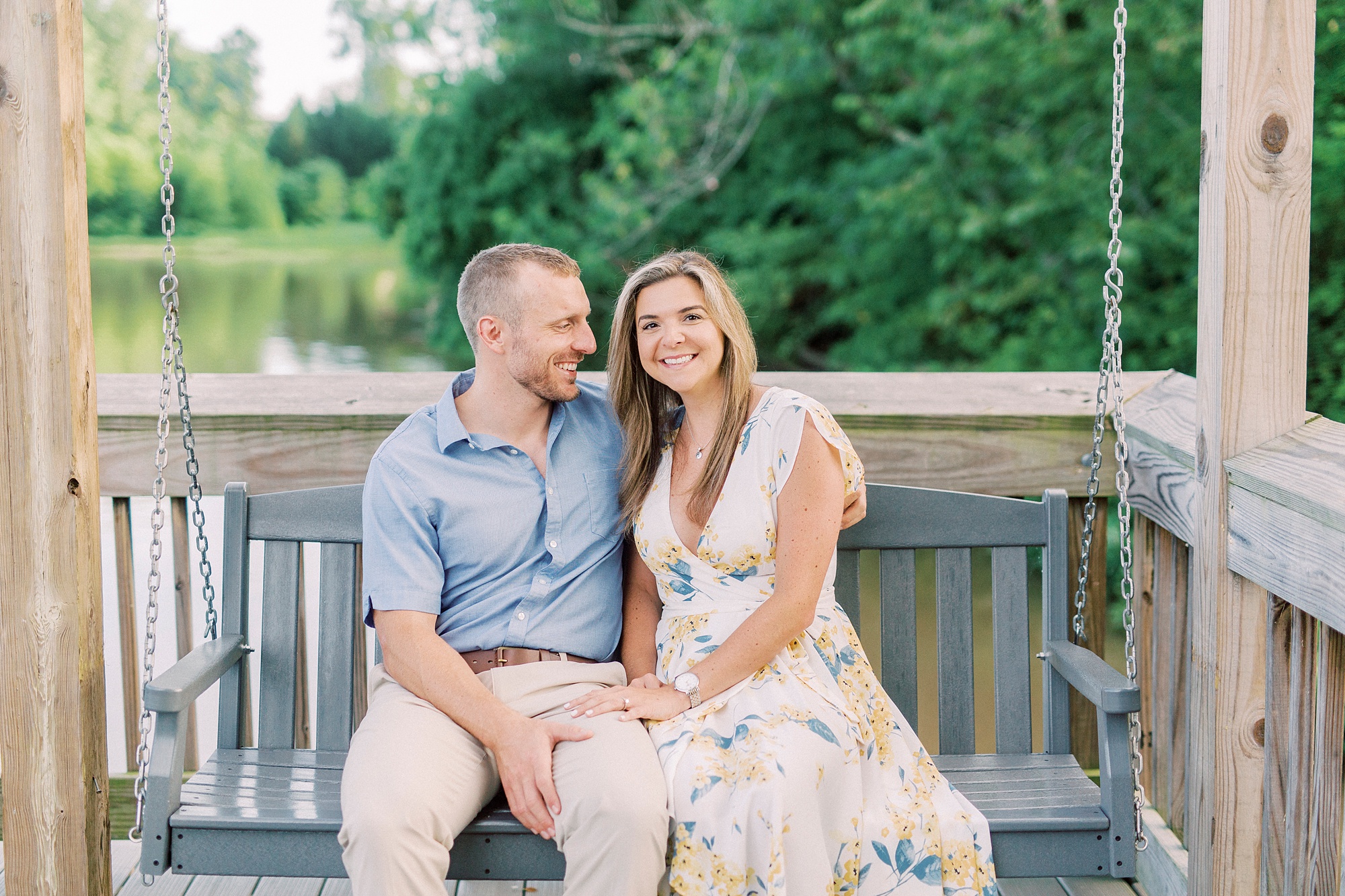 engaged couple sits on wooden bench in Kevin Loftin Park