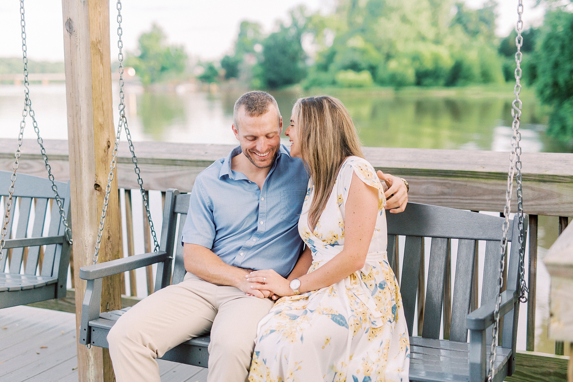 bride laughs with groom during NC engagement photos along waterfront