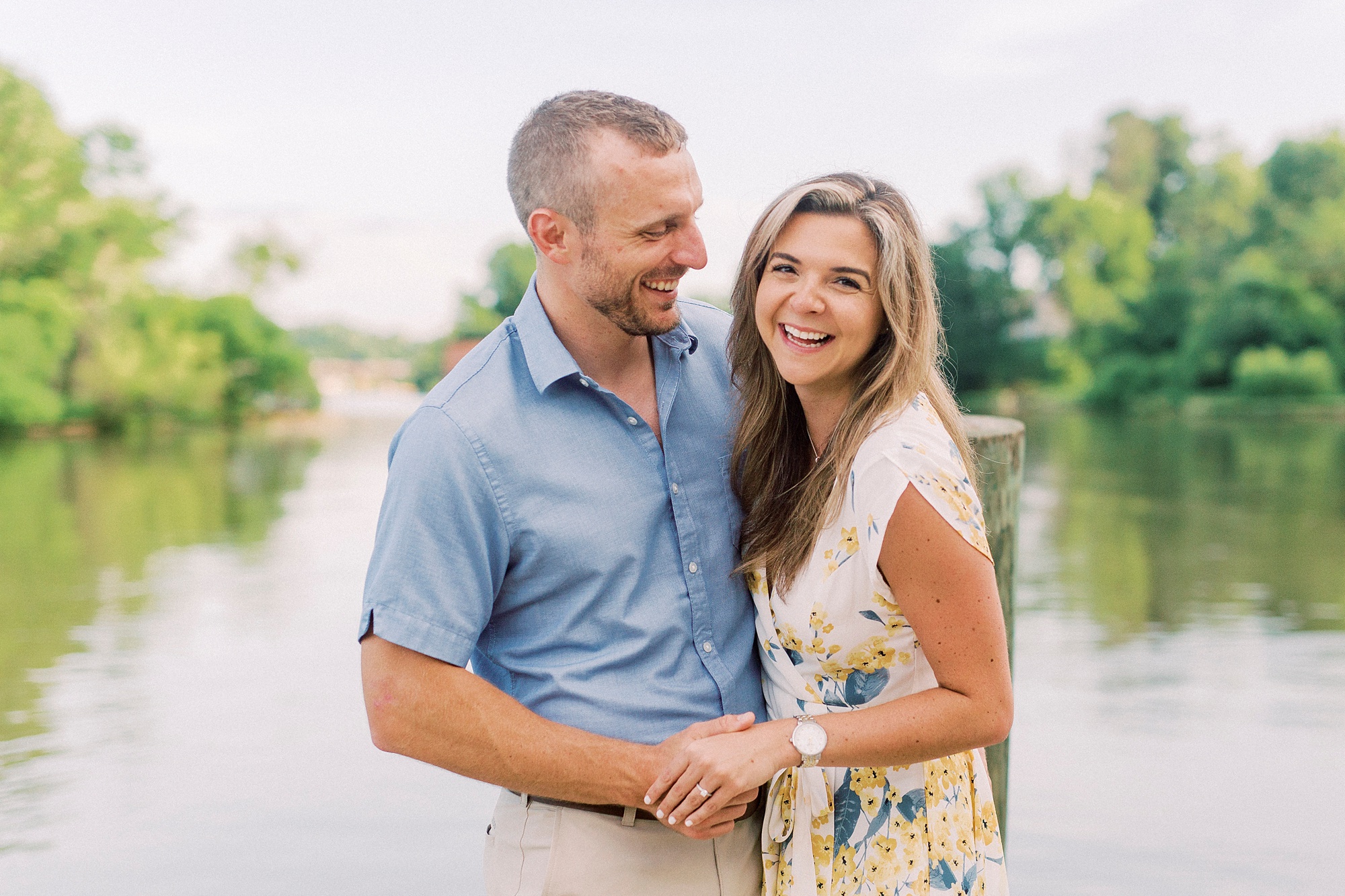 engaged couple laughs in front of water in NC