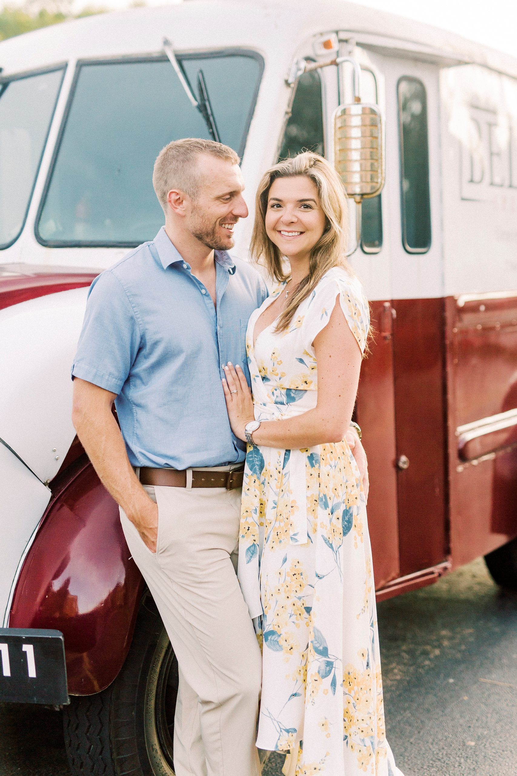bride and groom pose by red and white vintage truck