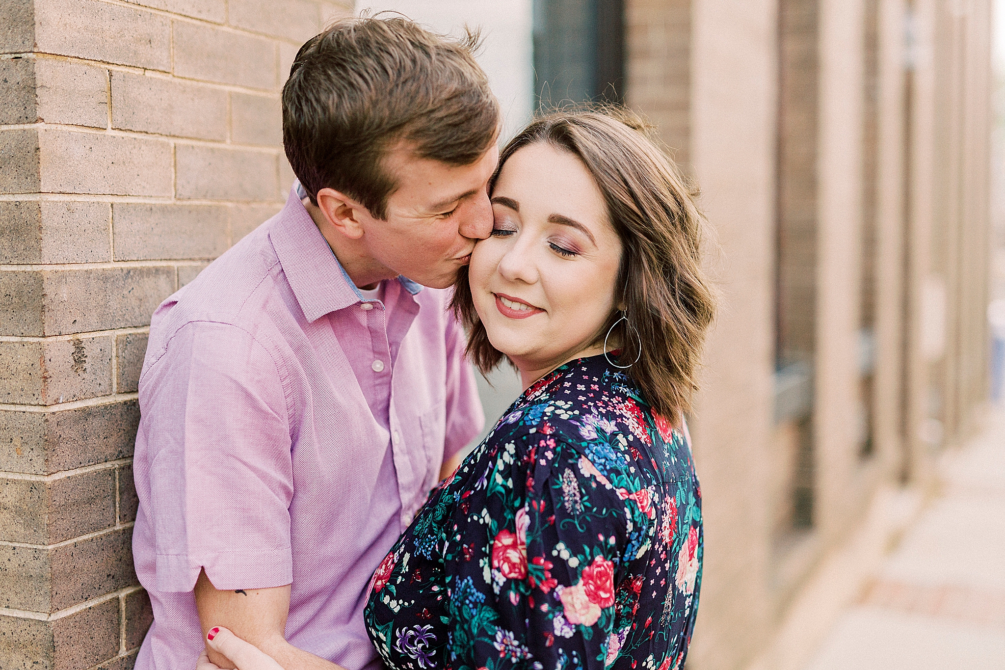 husband kisses wife's cheek during NC anniversary portraits