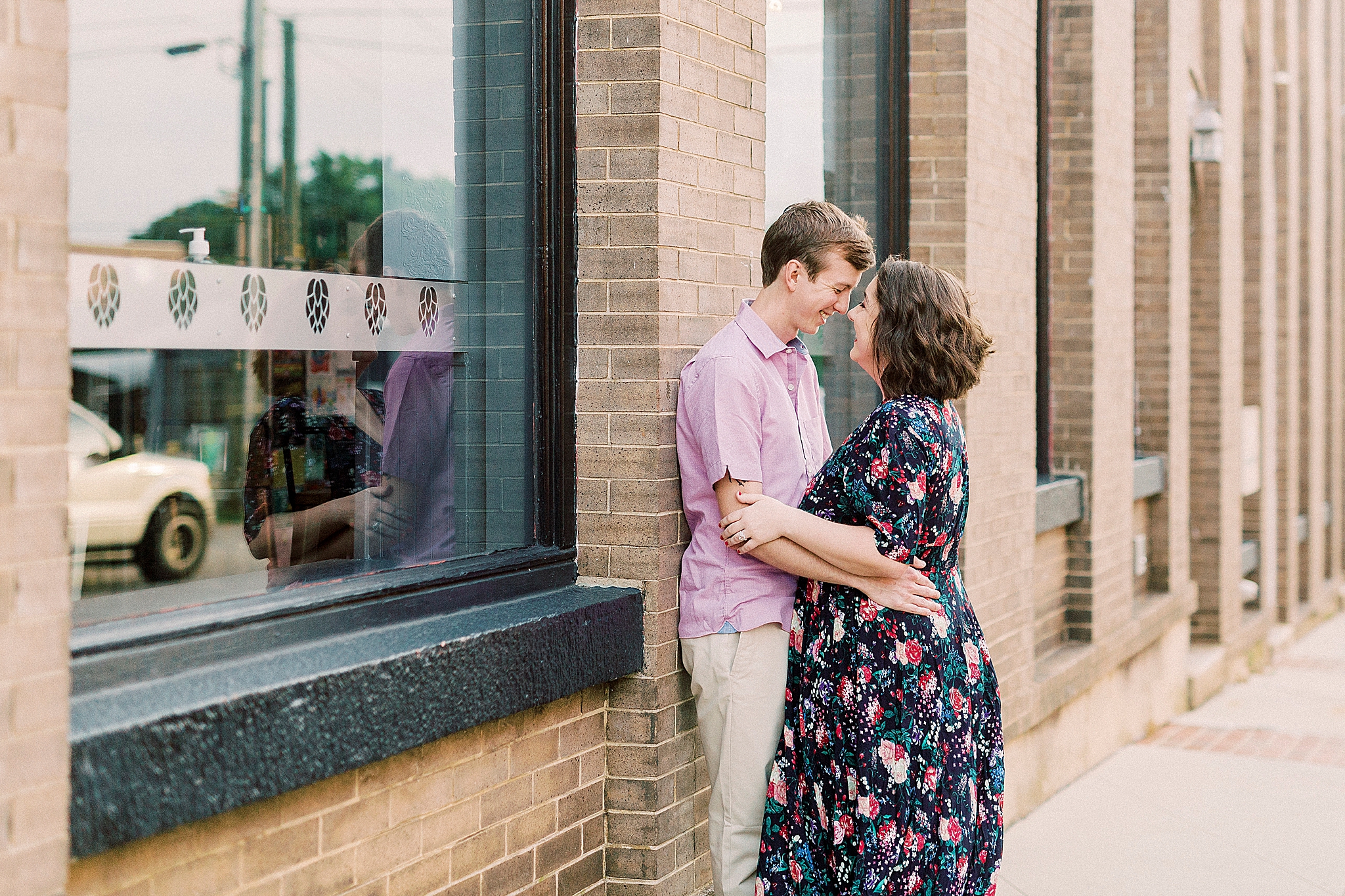 married couple poses nose to nose by On Tap in Downtown Mooresville