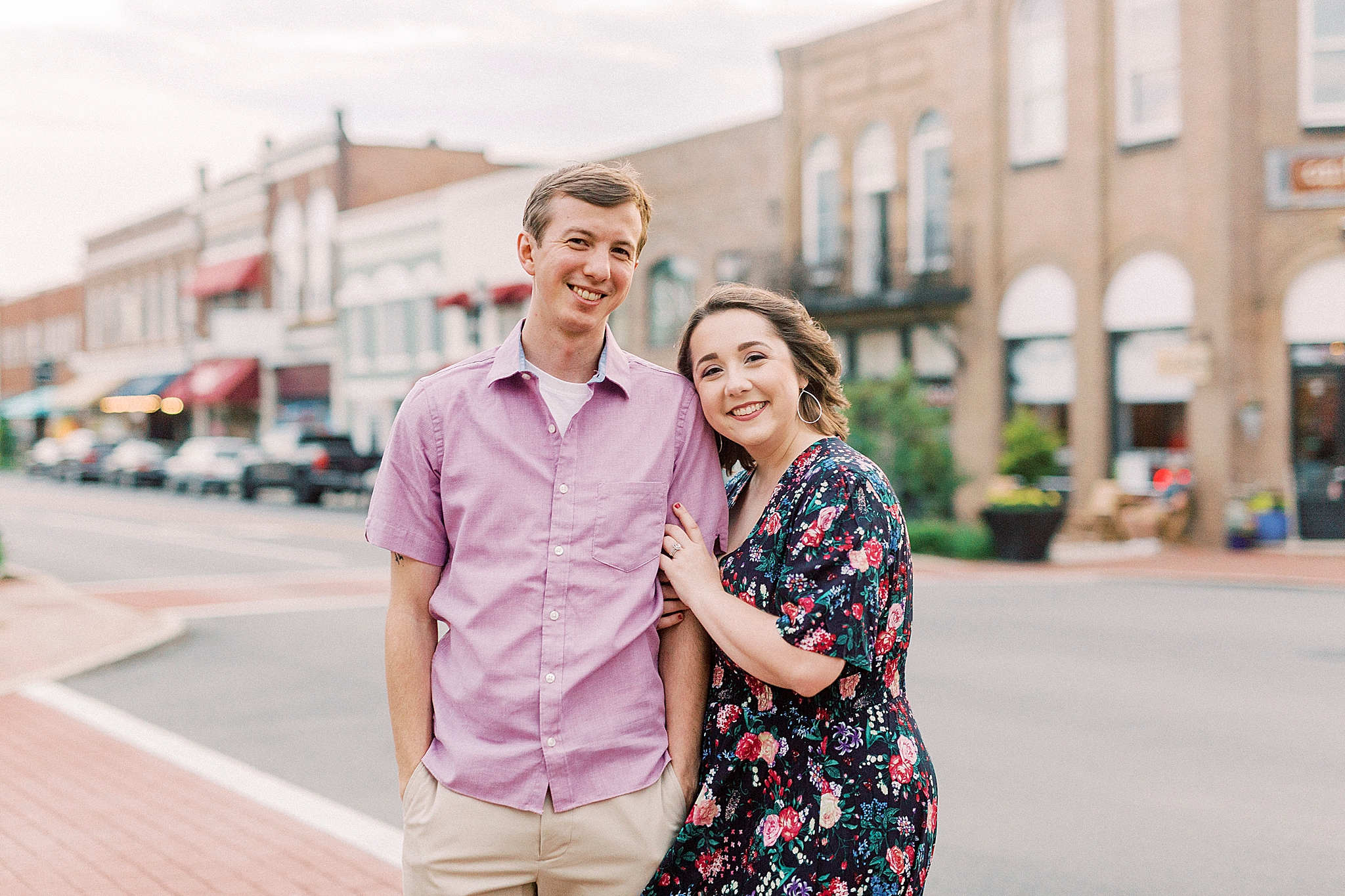 wife leans on husband's shoulder during Downtown Mooresville anniversary portraits