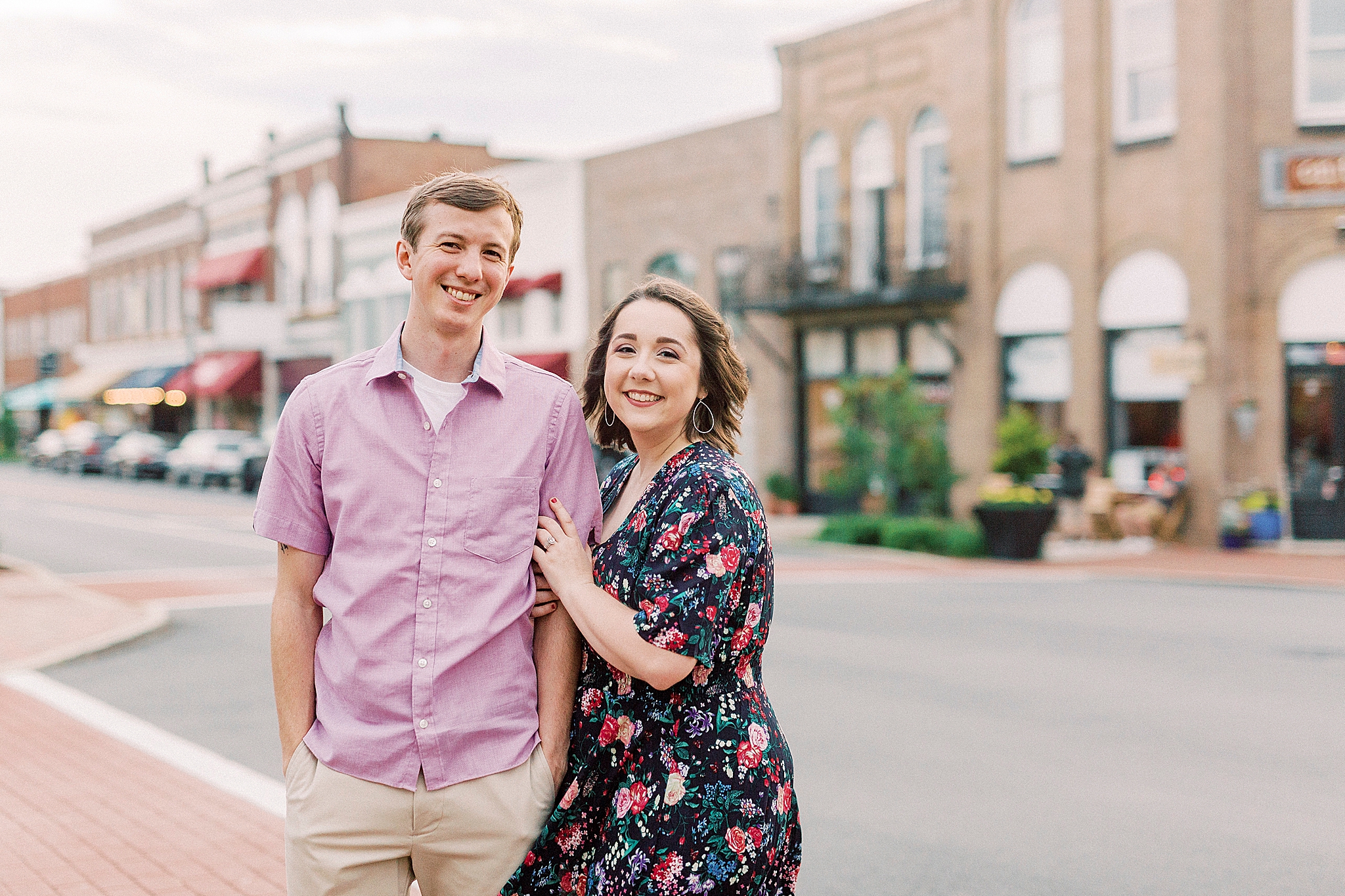 couple poses by downtown buildings in Mooresville