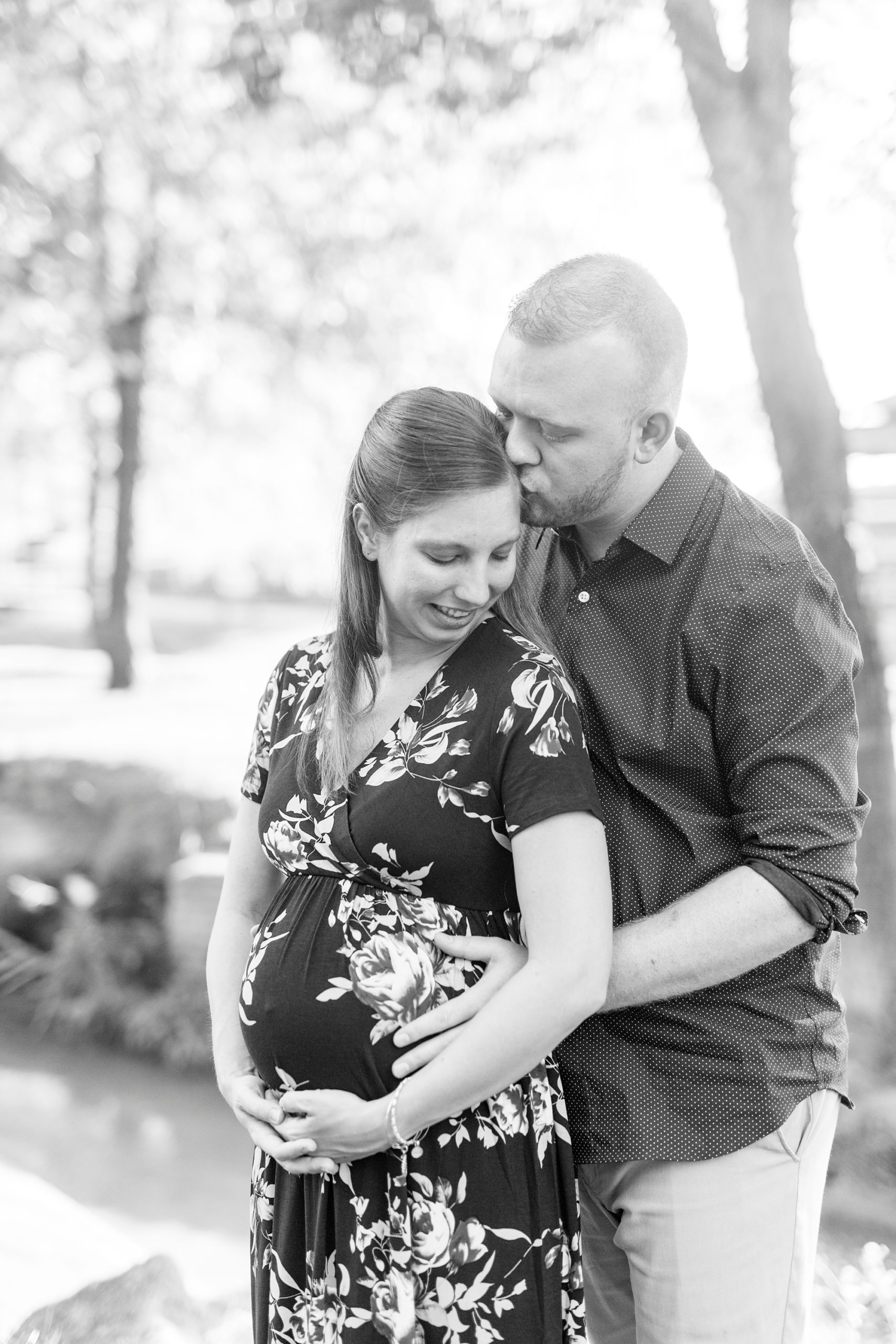 husband kisses wife's head during maternity photos at Rankin Lake Park