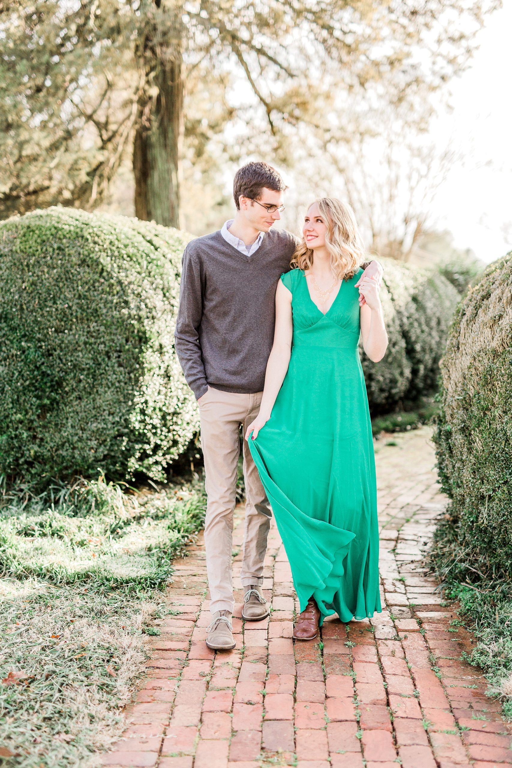 engaged couple walks down pathway outside the 1812 Hitching Post
