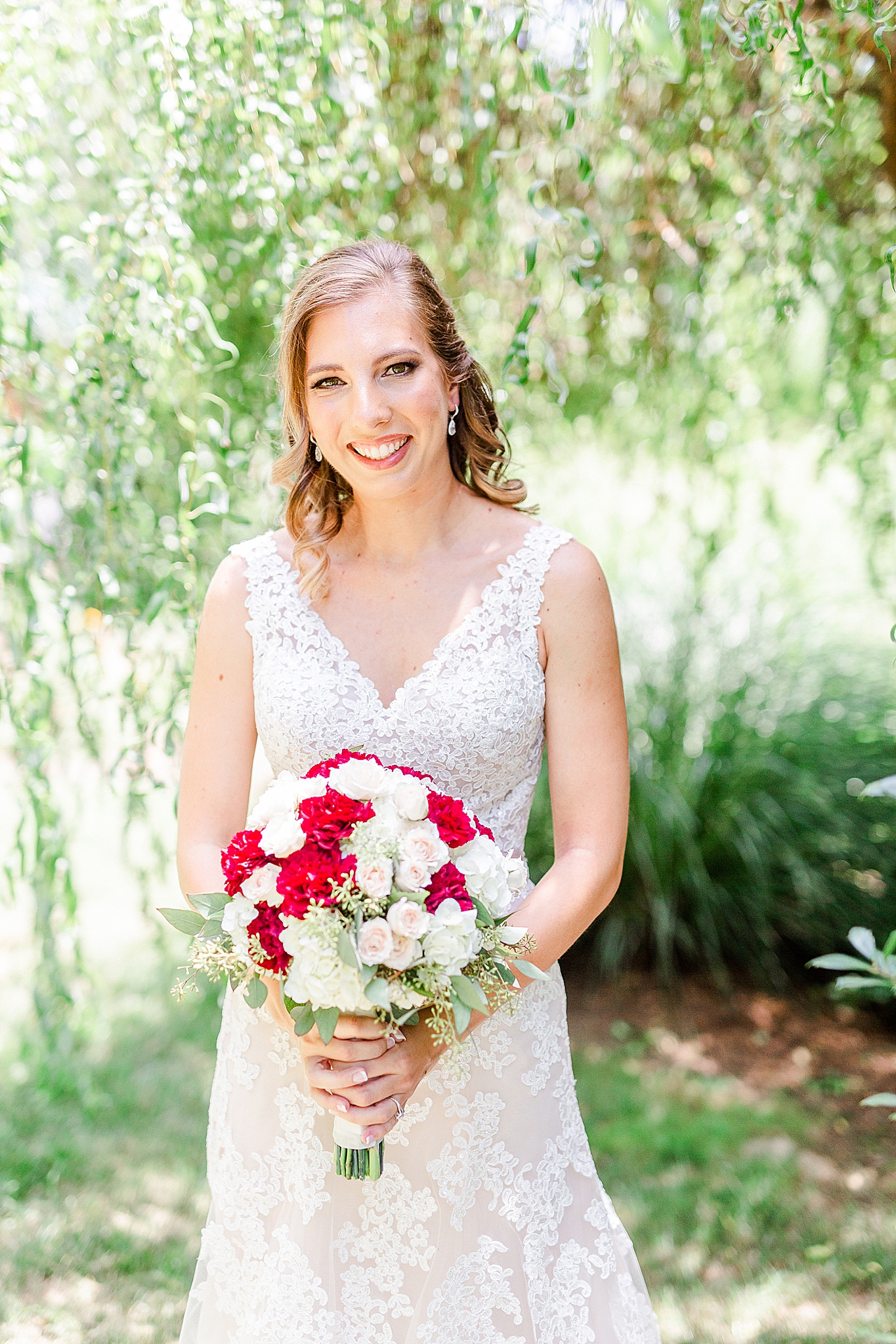 Alexander Homestead bridal portraits for bride holding red and white flowers