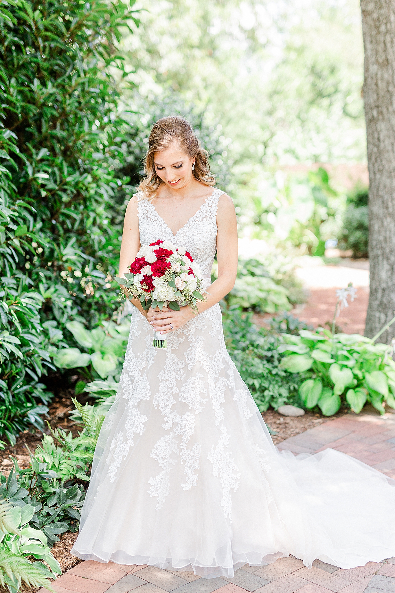 bride holds bouquet of white and red flowers