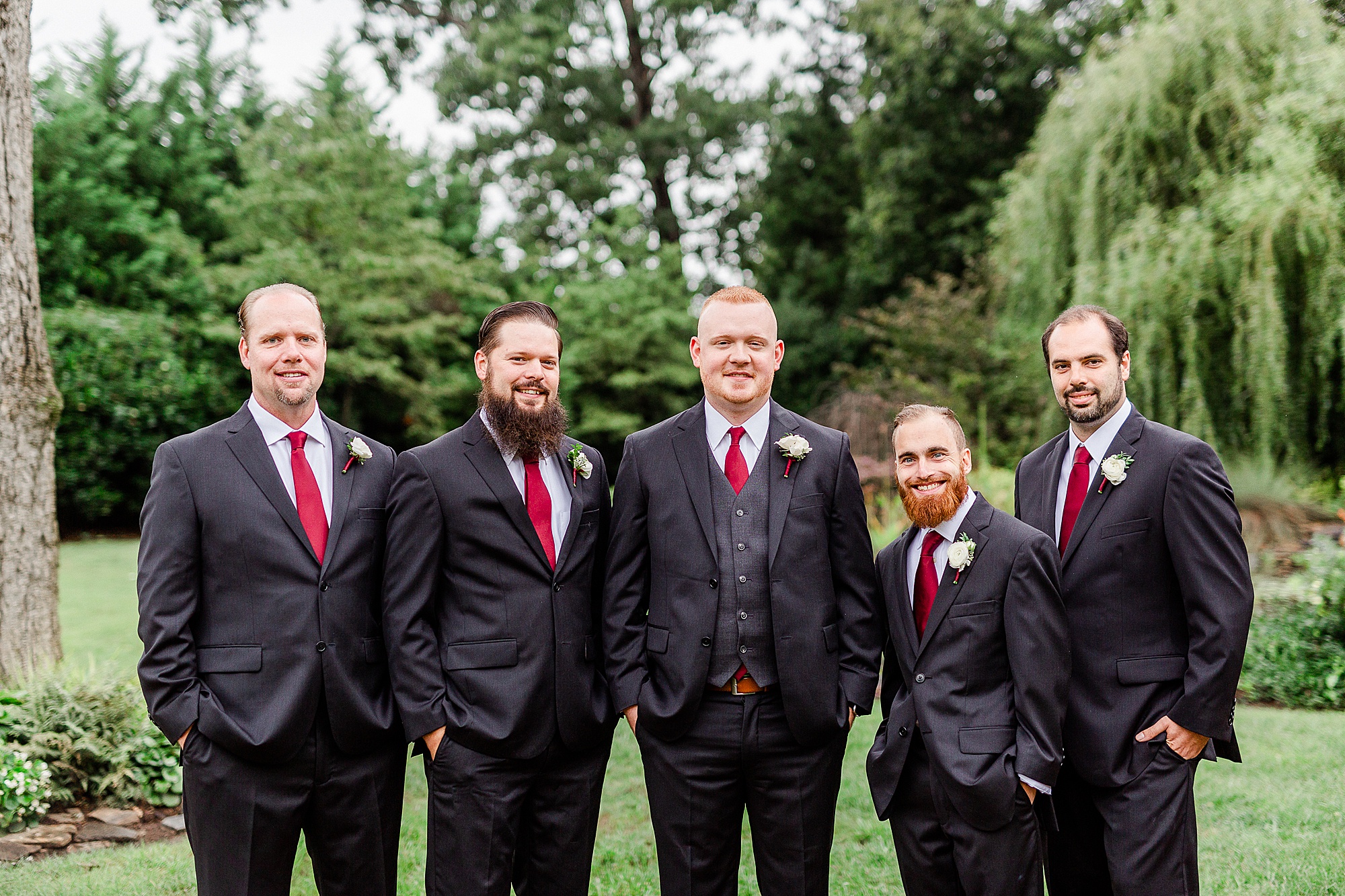 groom poses with four groomsmen