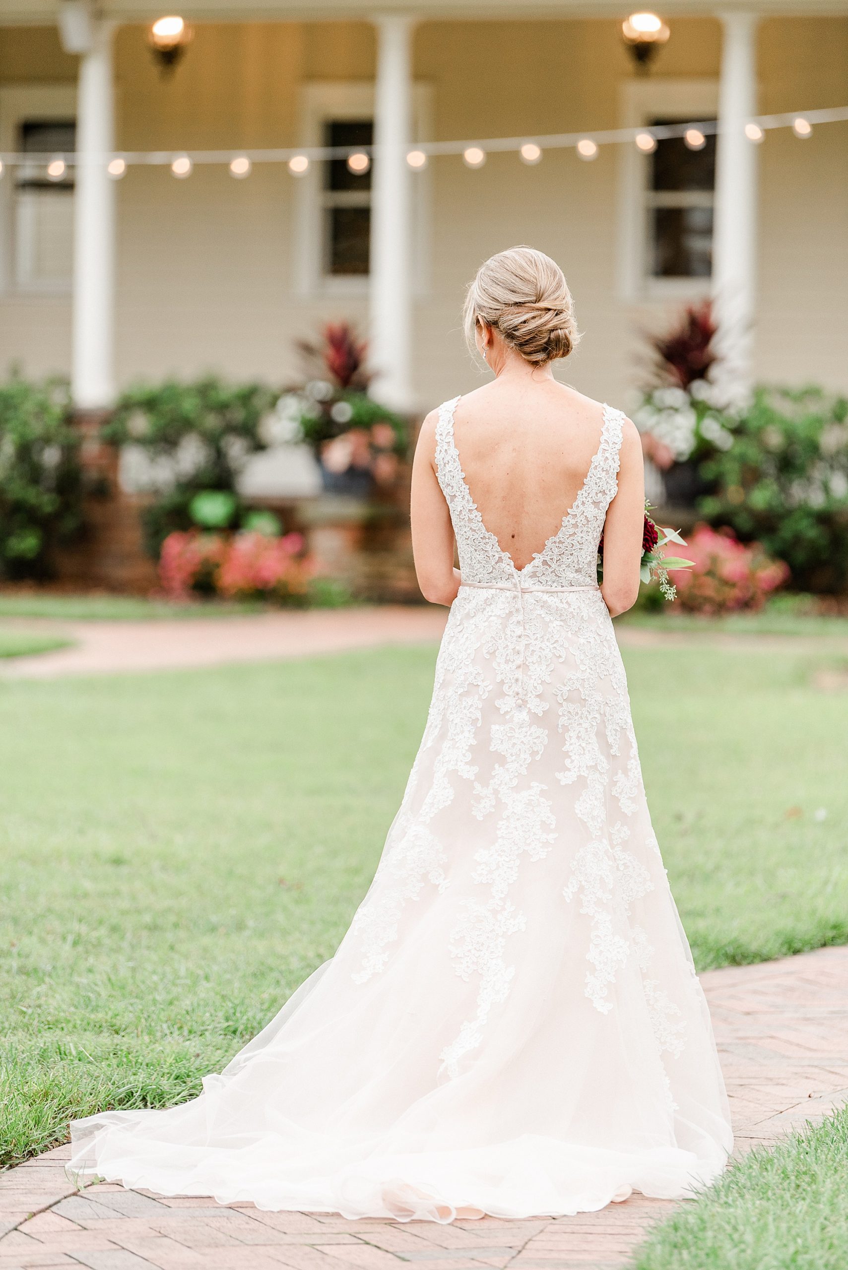 bride shows off back of wedding gown lace details