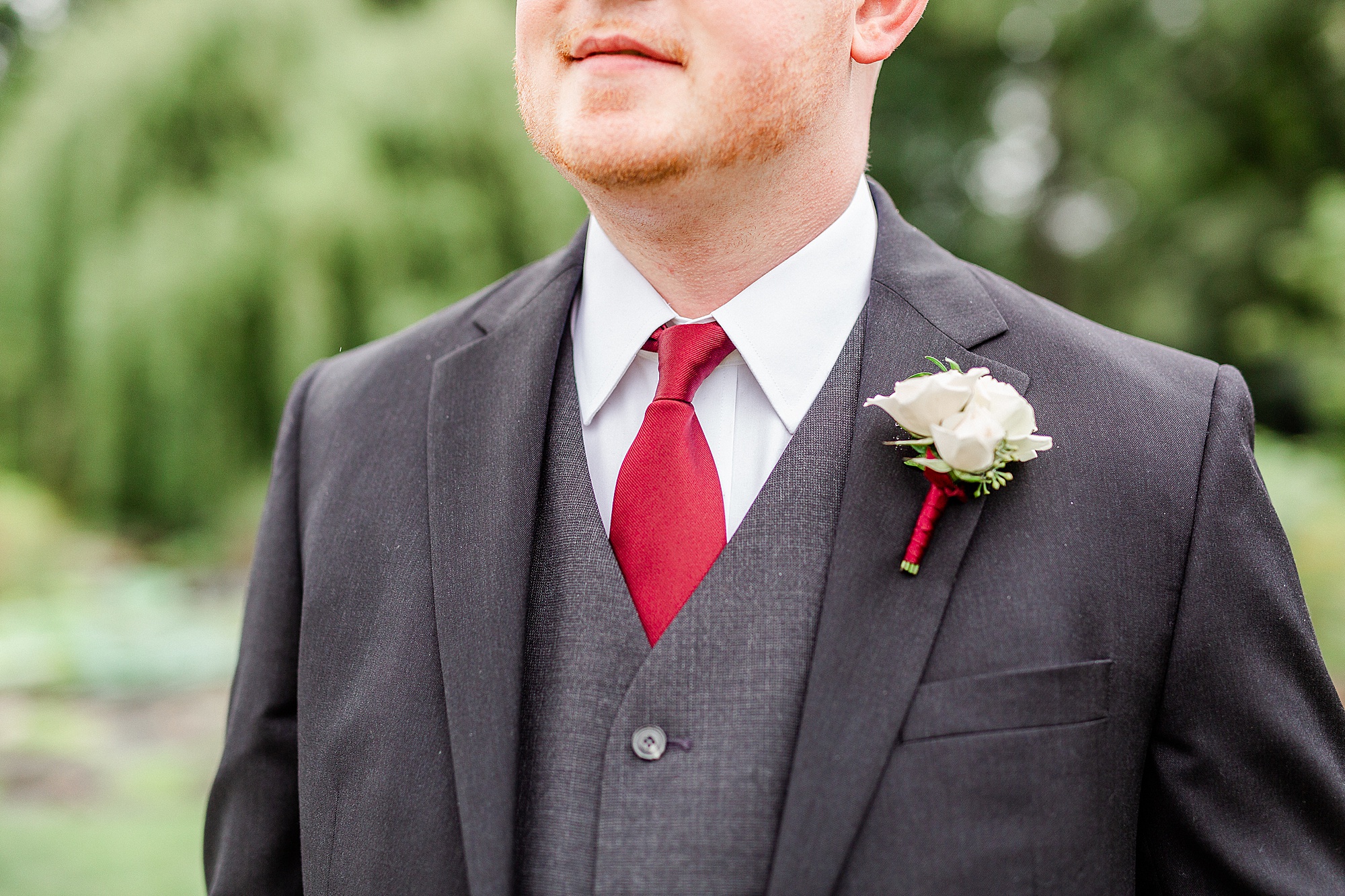 groom's look for summer wedding with black suit and red tie